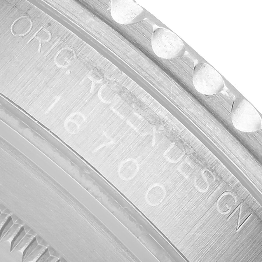 The image shows a close-up of the bezel and engraved text on the side of a Rolex GMT-Master 16700 Men's Stainless Steel Black Dial watch, highlighting its design details.