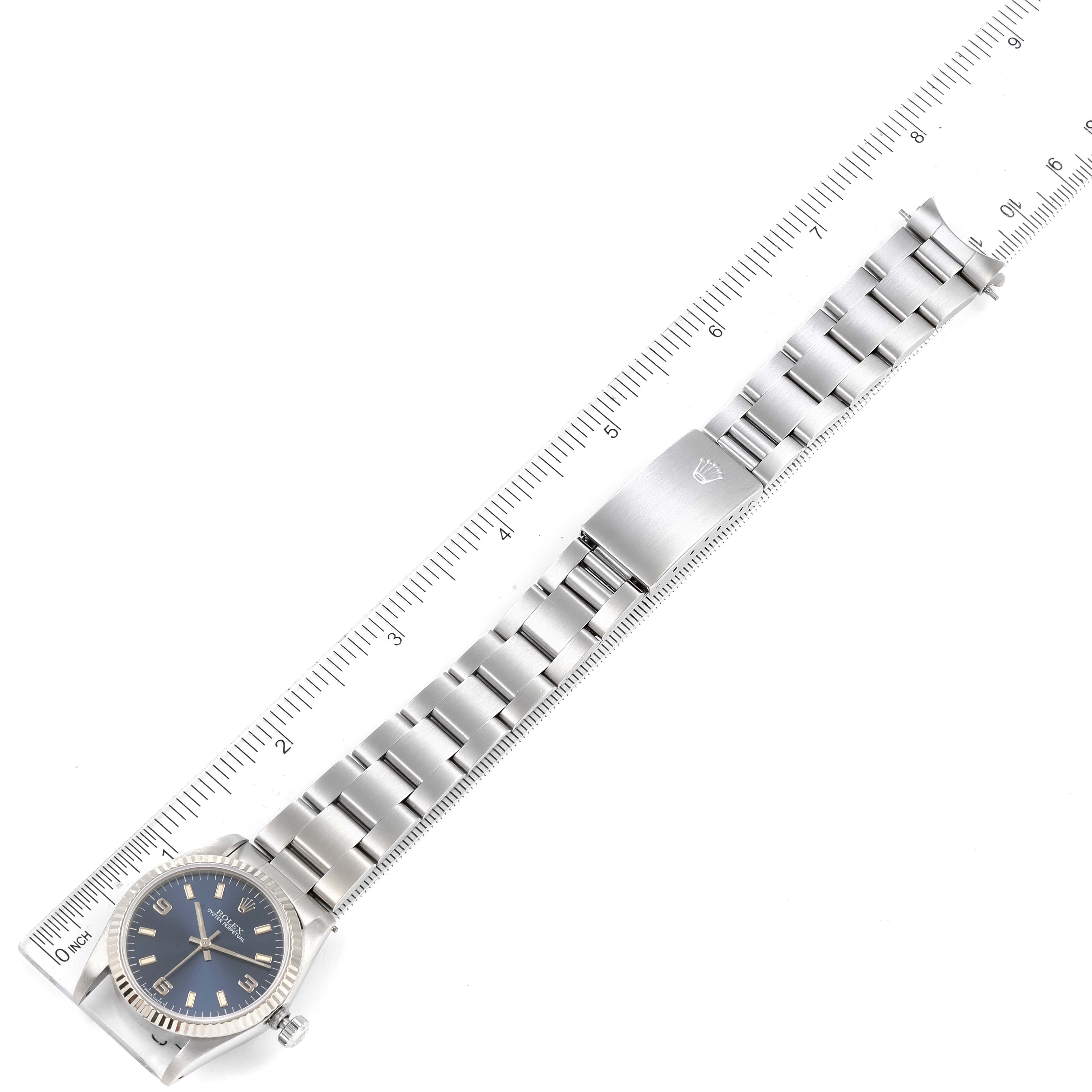 The image displays a Rolex Mid-Size 67514 Women
s Stainless Steel Blue Dial 67514 Women
s Stainless Steel Blue Dial watch laid flat with a ruler alongside for size reference.