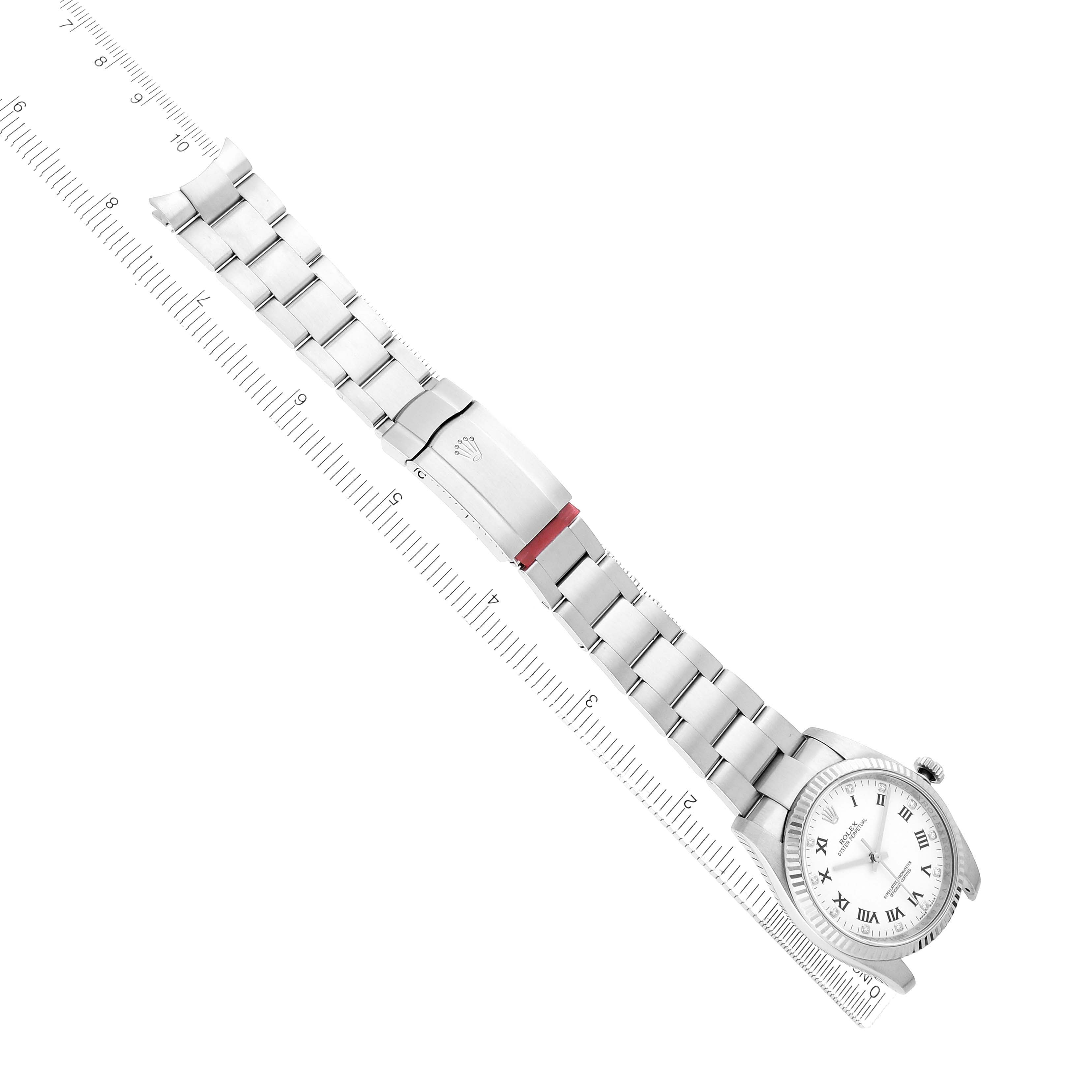 The Rolex Oyster Perpetual 116034 Men
s Stainless Steel White Dial watch is shown at an angle, highlighting the bracelet, clasp, and face alongside a ruler for scale.