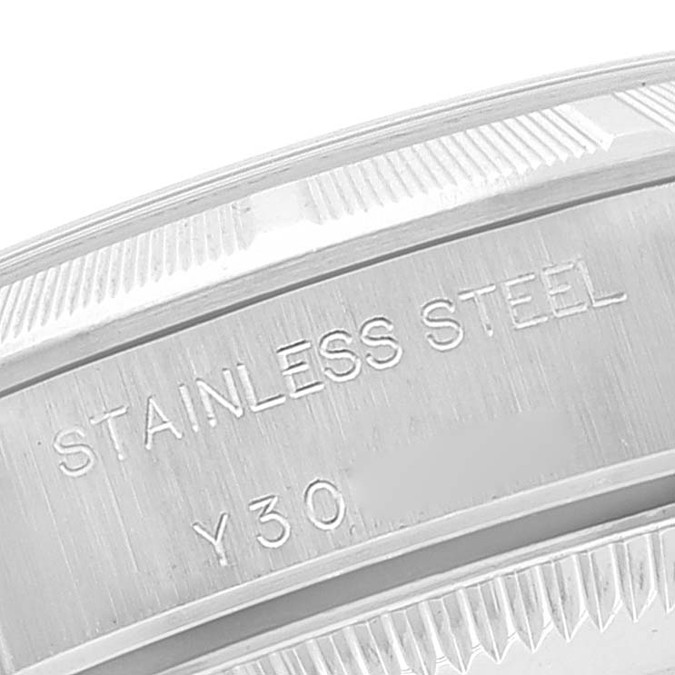 This close-up image shows the stainless steel casing and part of the engraved markings on a Rolex Oyster Perpetual 76030 Women
s Stainless Steel Pink Dial 76030 Women
s Stainless Steel Pink Dial watch.