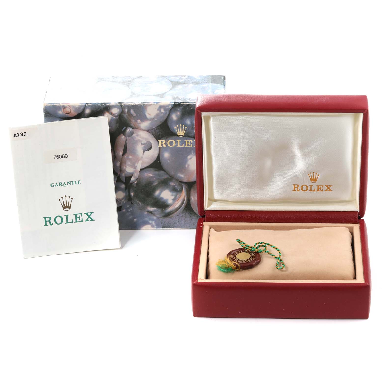 This image shows the packaging, warranty booklet, and a tag for a Rolex Oyster Perpetual 76080 Women's Stainless Steel Pink Dial 76080 Women's Stainless Steel Pink Dial watch.