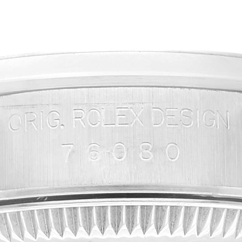 The image shows a close-up of the case back edge of a Rolex Oyster Perpetual 76080 Women's Stainless Steel Pink Dial 76080 Women's Stainless Steel Pink Dial watch, detailing the model number and branding.