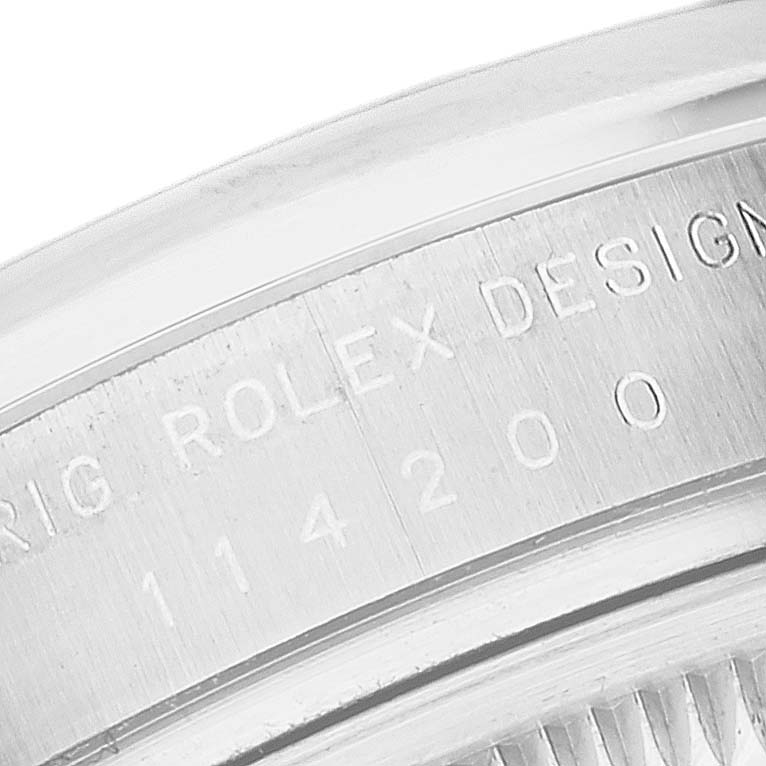 This image shows a close-up of the case back with engravings on a Rolex Oyster Perpetual 114200 Men
s Stainless Steel White Dial 114200 Men
s Stainless Steel White Dial watch.