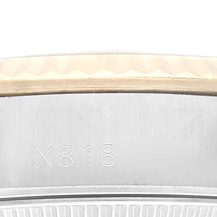 This image shows an extreme close-up of the side of a Rolex Oyster Perpetual 67193 Women's Steel and Gold (two tone) Champagne Dial 67193 Women's Steel and Gold (two tone) Champagne Dial watch, focusing on the case edge engraving.