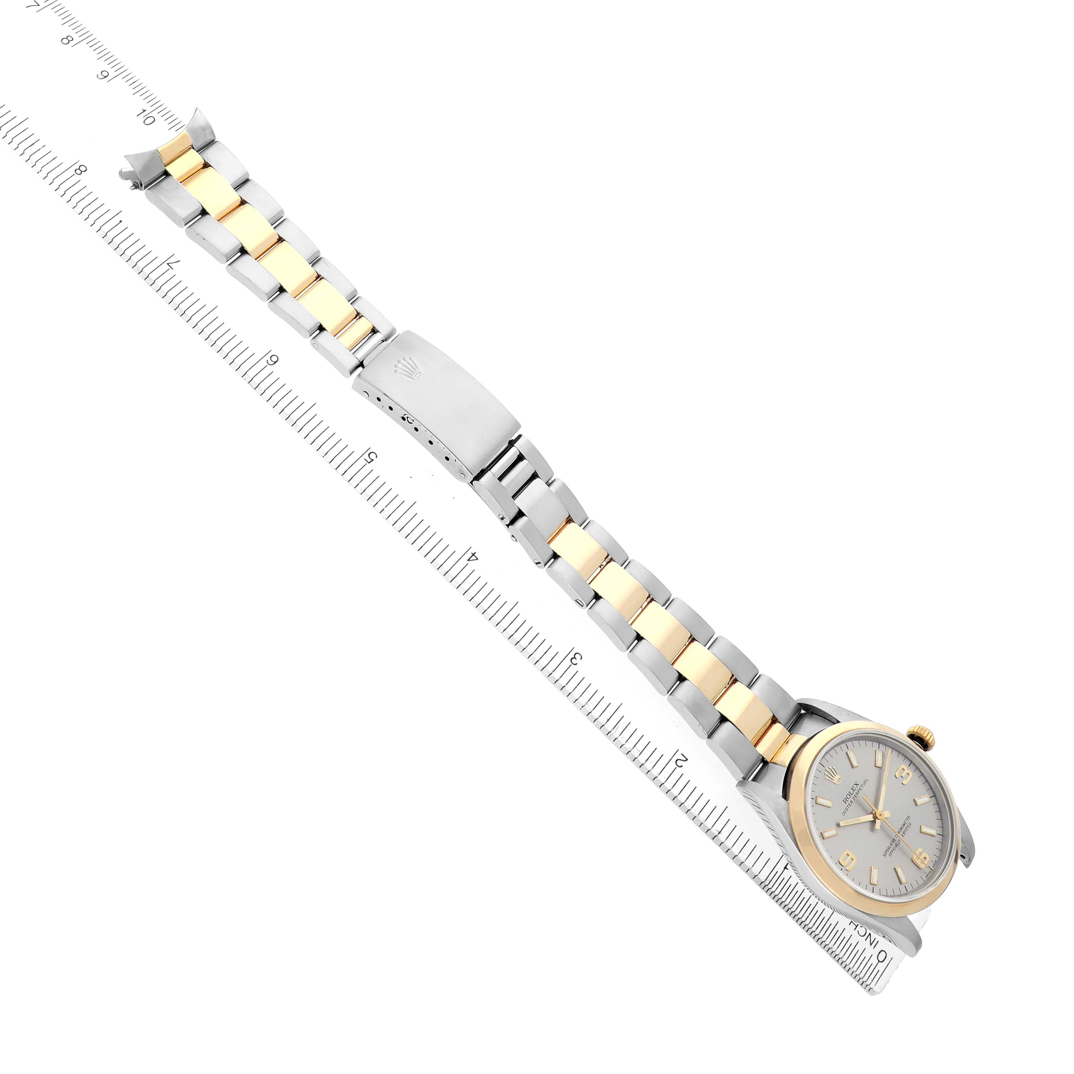 The Rolex Oyster Perpetual 14203 Men
s Steel and Gold (two tone) Silver Dial watch is shown at a slight overhead angle, featuring the watch face, two-tone bracelet, and clasp.