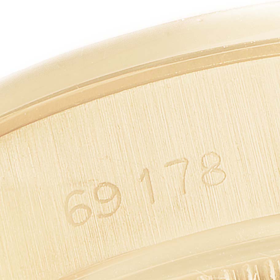 The image shows a close-up of the engraved back case of a Rolex President 69178 Women's Yellow Gold Black Dial 69178 Women's Yellow Gold Black Dial model watch.