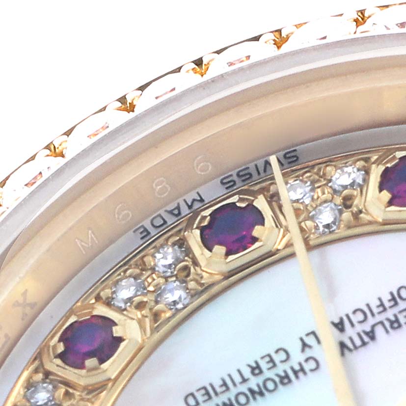 This close-up of the Rolex President 179138 Men's Yellow Gold Mother of Pearl Dial watch shows part of the bezel with diamonds, rubies, and the "Swiss Made" inscription.