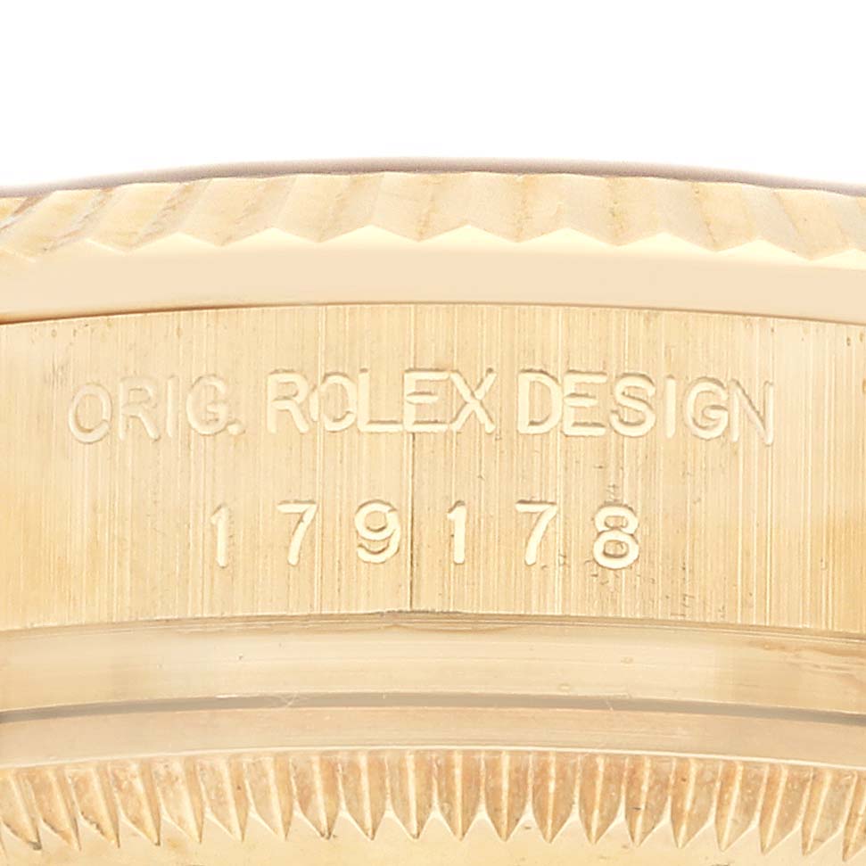 The image shows a close-up of the side of a Rolex President 179178 Women's Yellow Gold White Dial model watch case, featuring engraved design and model number details.
