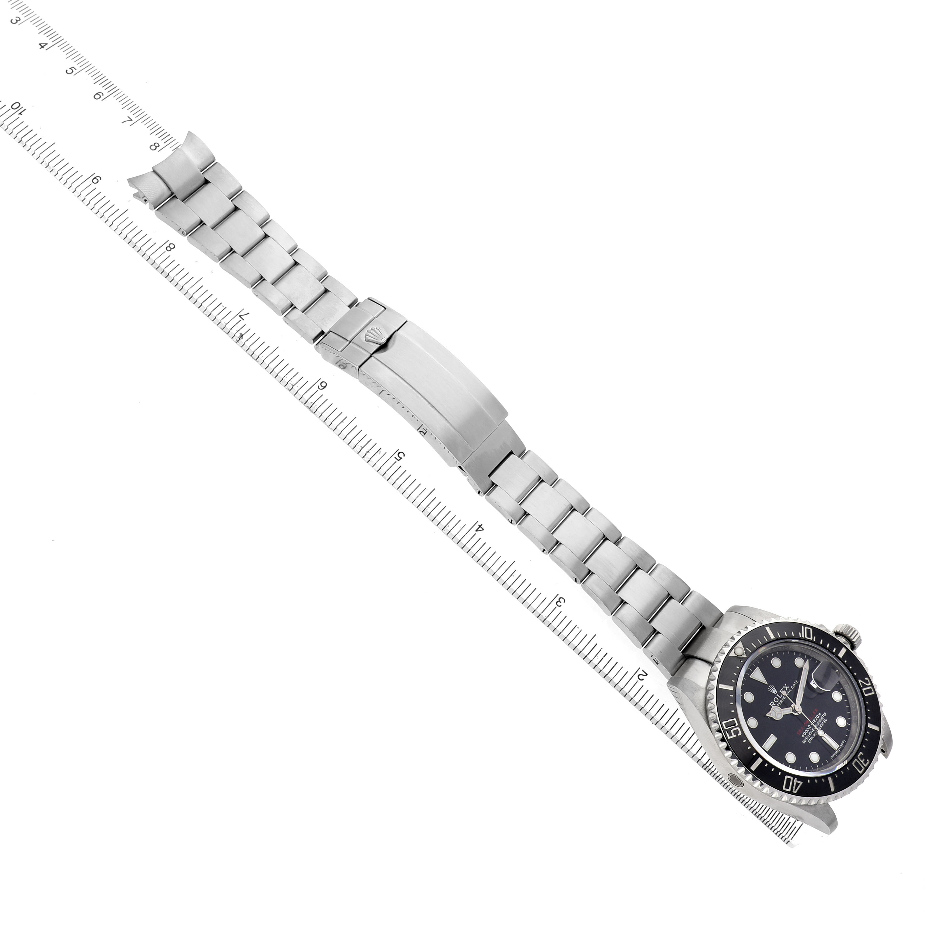 The Rolex Sea-Dweller 126600 Men's Stainless Steel Black Dial is shown flat from a top angle, with the full bracelet and clasp visible alongside a ruler.