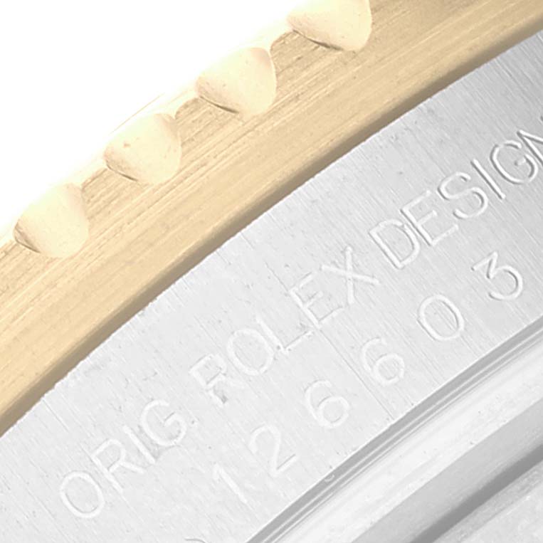 The image shows a close-up of the bezel and engraving on the side of a Rolex Sea-Dweller 126603 Men
s Steel and Gold (two tone) Black Dial 126603 Men
s Steel and Gold (two tone) Black Dial watch.