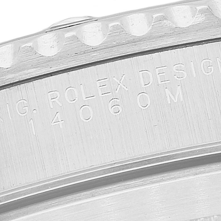 This close-up image shows the engraved outer bezel and part of the case of a Rolex Submariner 14060 Men
s Stainless Steel Black Dial 14060 Men
s Stainless Steel Black Dial.