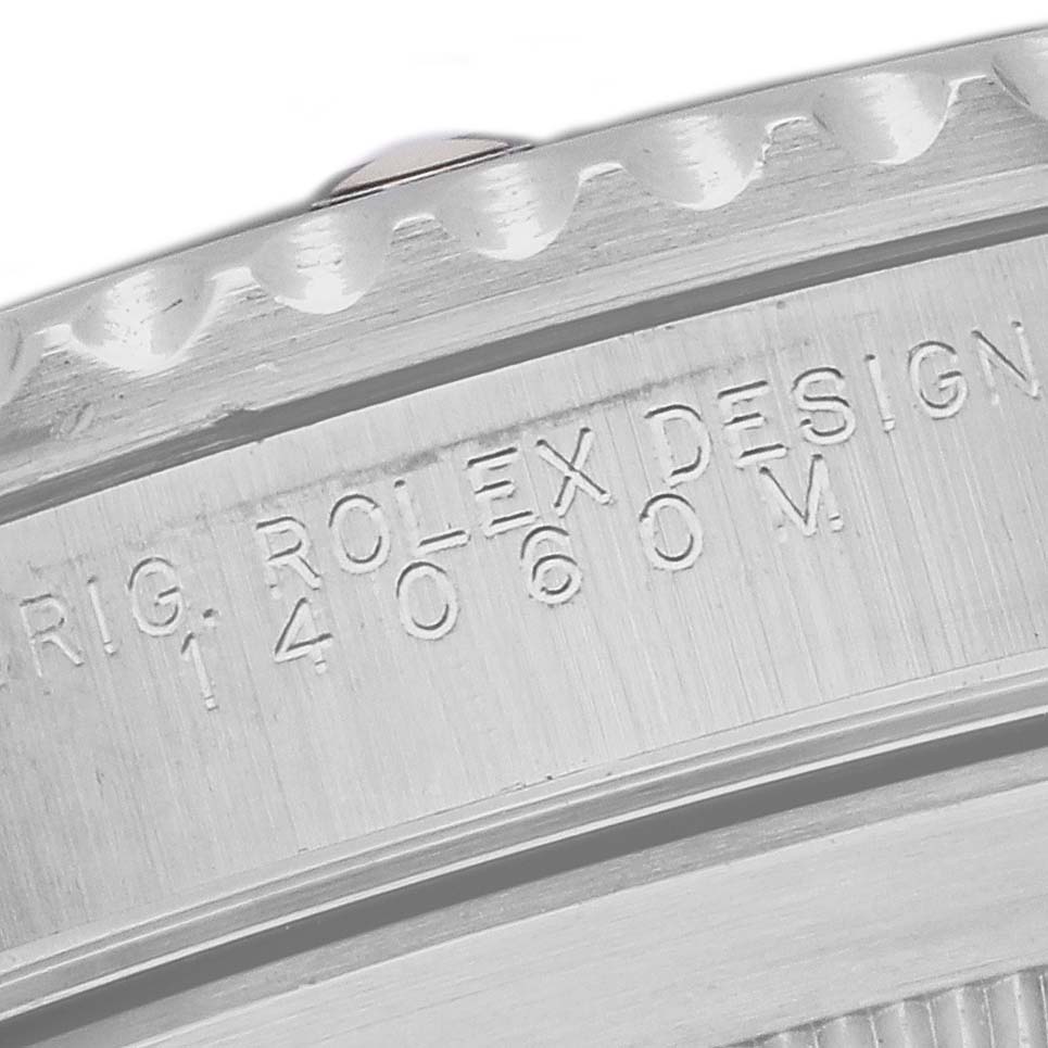 The image shows a close-up of the case back edge of a Rolex Submariner 14060 Men
s Stainless Steel Black Dial, displaying the engraved model number and "Rolex Design."