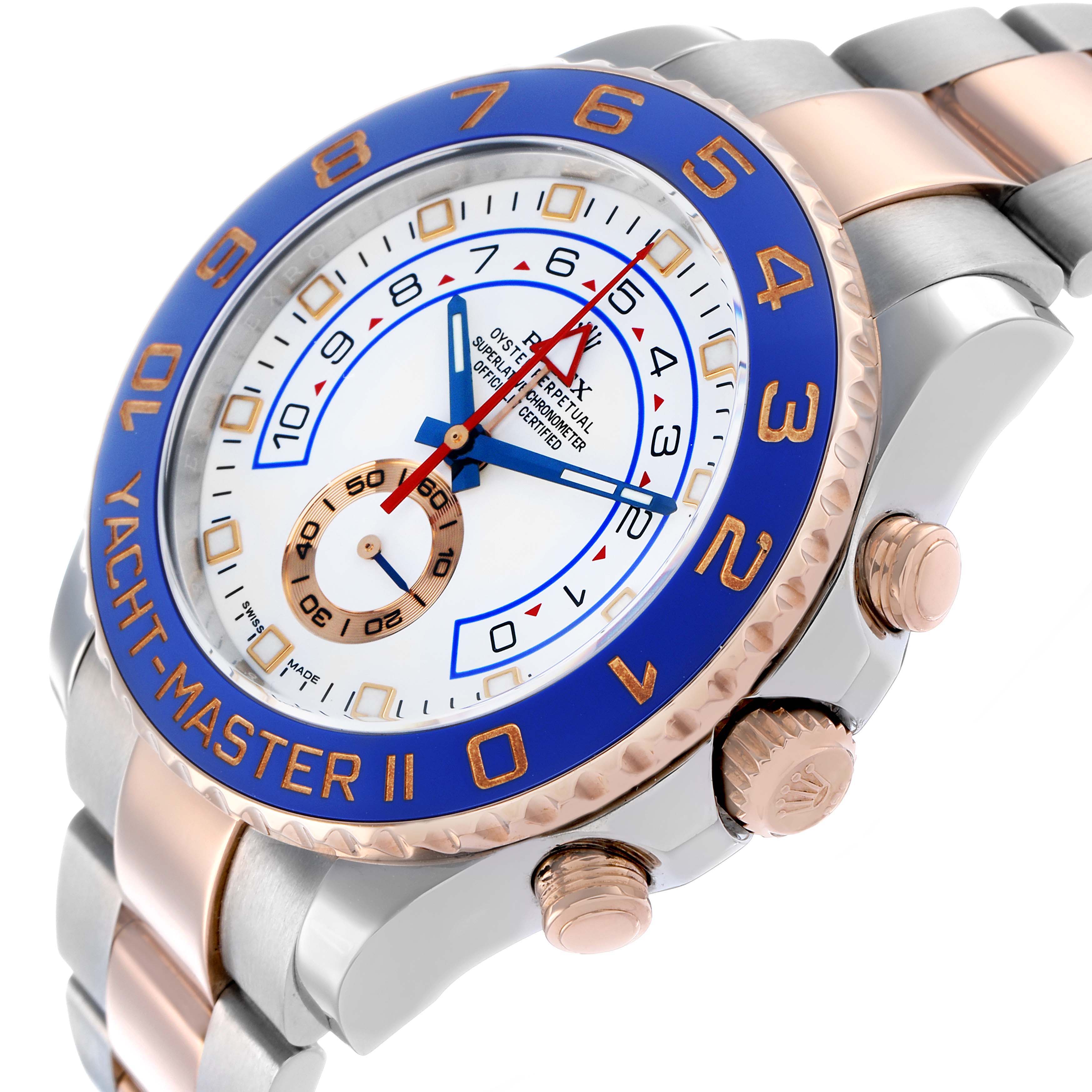 The image shows the Rolex Yacht-Master 116681M Men
s Steel and Gold (two tone) White Dial II at an angle highlighting the blue bezel, dial, case, crown, and two-tone bracelet.