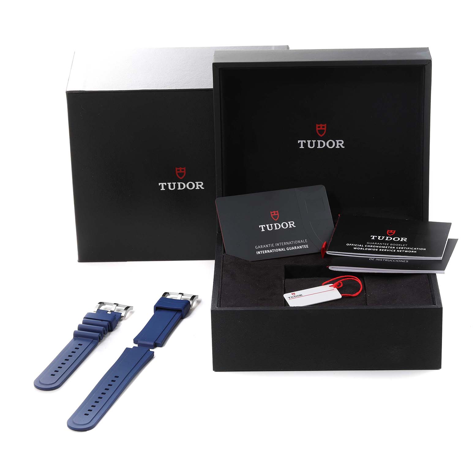 The image shows the packaging, warranty cards, a tag, and an extra blue strap for the Tudor Pelagos 25600TB Men's Titanium Blue Dial 25600TB Men's Titanium Blue Dial watch.