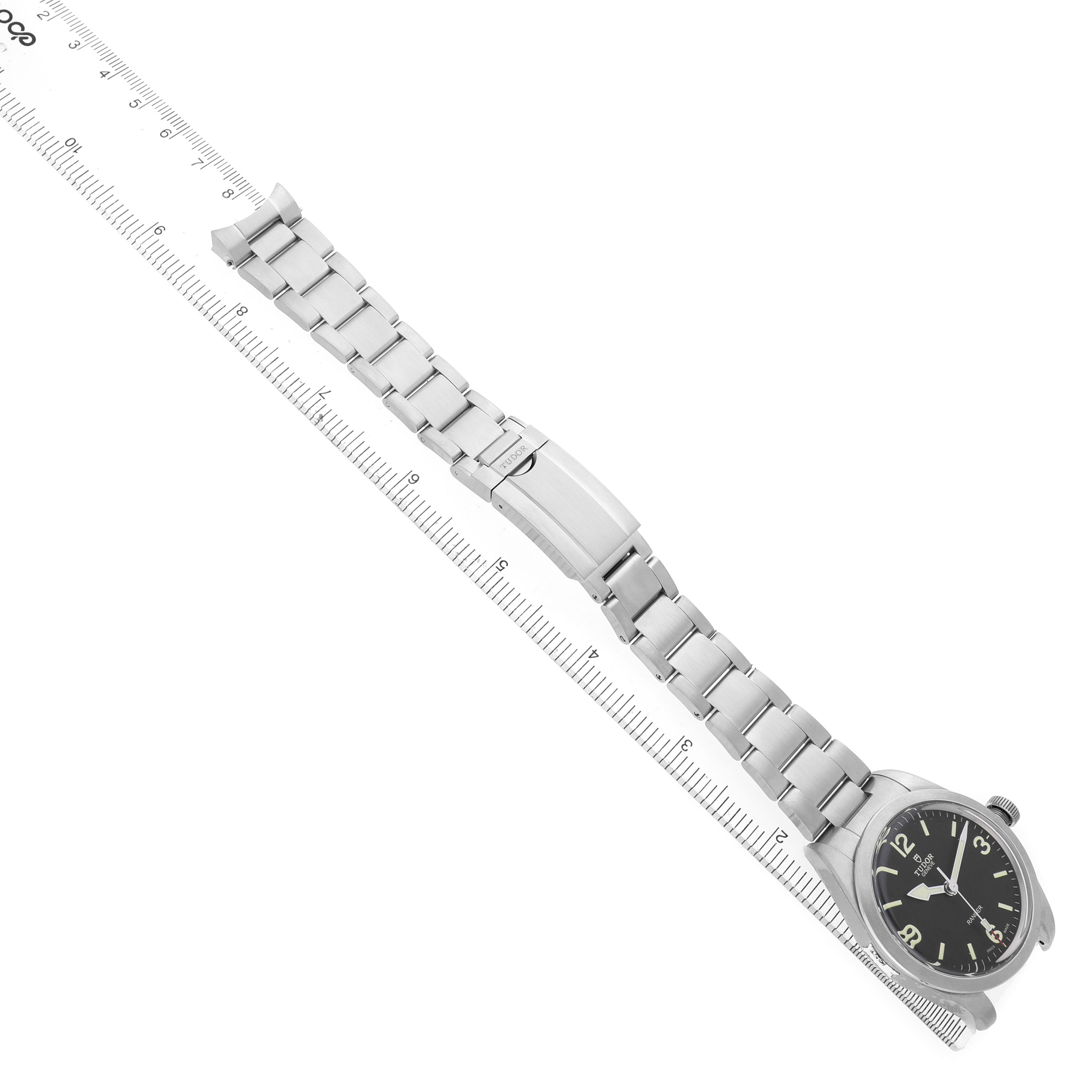 The Tudor Heritage Ranger 79950 Men's Stainless Steel Black Dial watch is shown at an angle displaying its case, dial, and full bracelet.