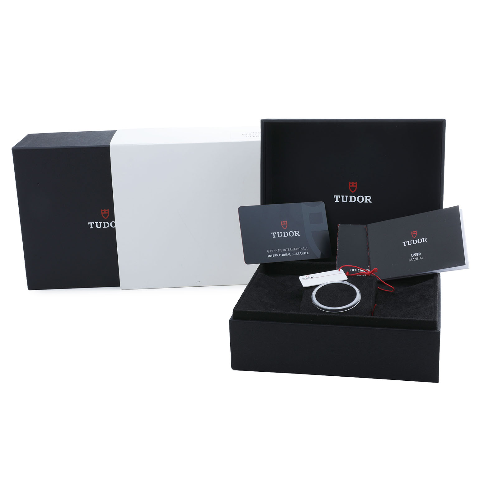 The image shows packaging and accessories for the Tudor Heritage Ranger 79950 Men's Stainless Steel Black Dial, including boxes, manuals, and a tag.