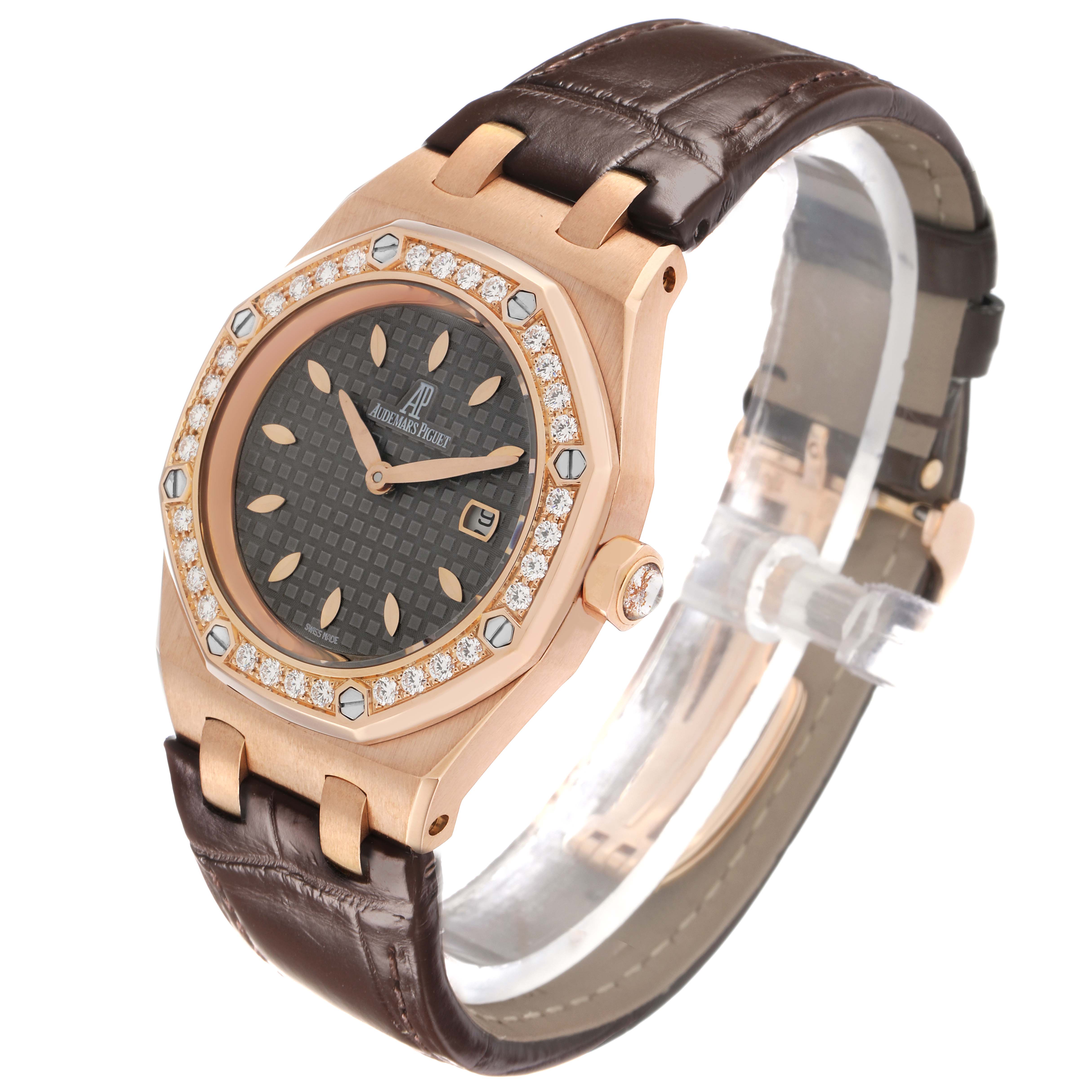 The Audemars Piguet Royal Oak 67621OR Women's Rose Gold Grey Dial watch is shown at a three-quarter angle, highlighting its diamond-set bezel, dial, and brown leather strap.