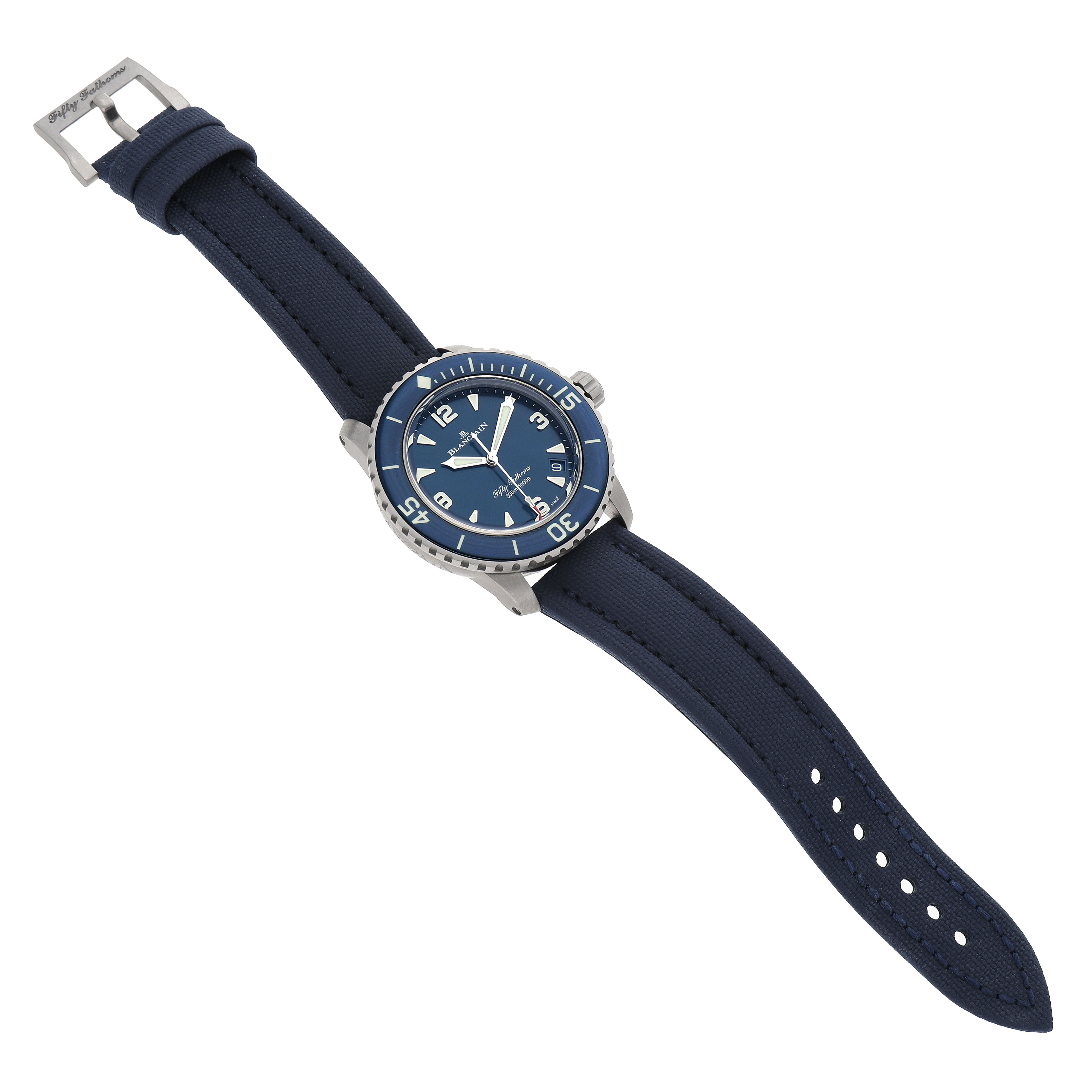 The Fifty Fathoms by Blancpain is shown at a slight angle, highlighting the blue dial, bezel, strap, and buckle.