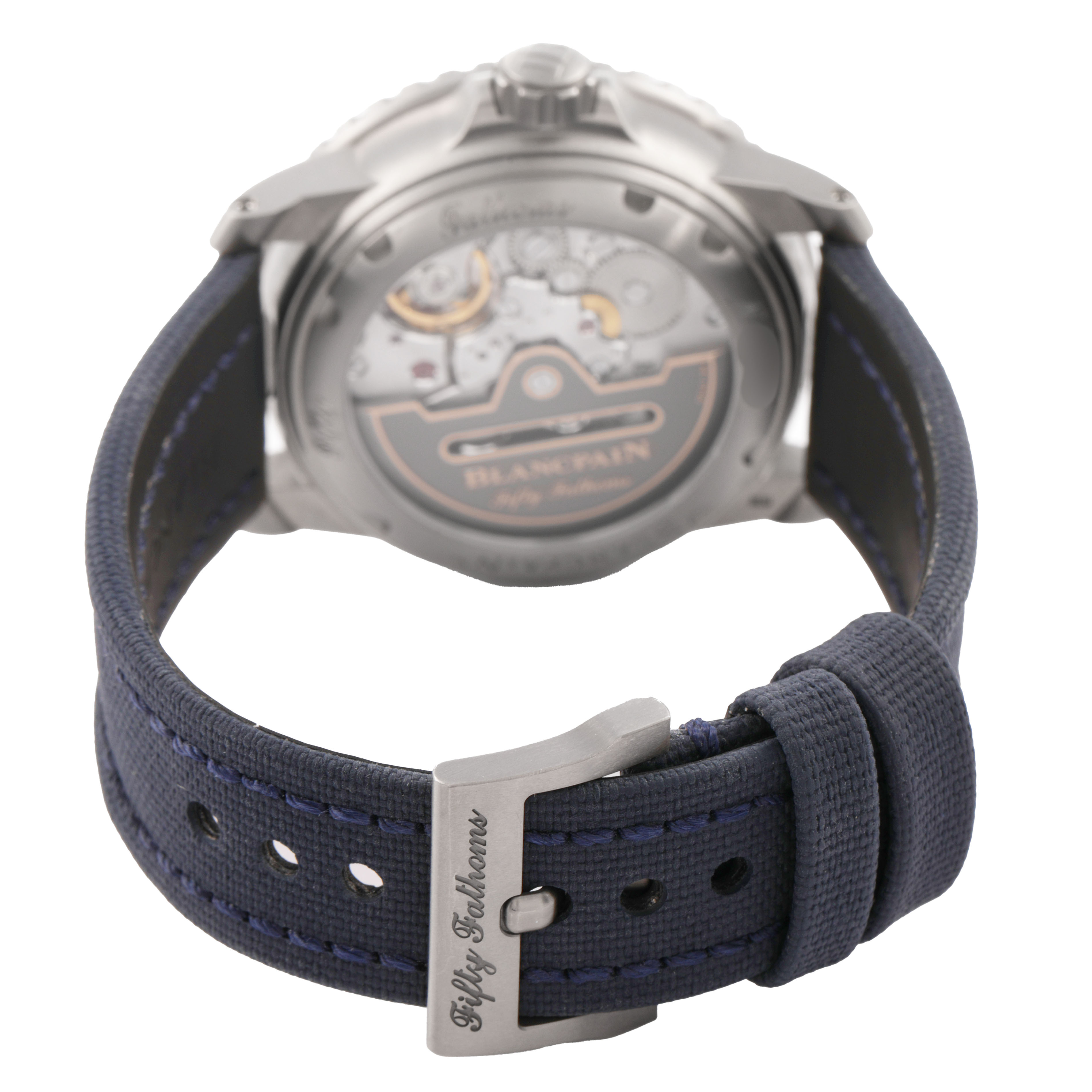 The image shows the back of the Blancpain Fifty Fathoms 5010-12B40-O52A Men's Titanium Blue Dial watch, highlighting the movement and the strap with its buckle.