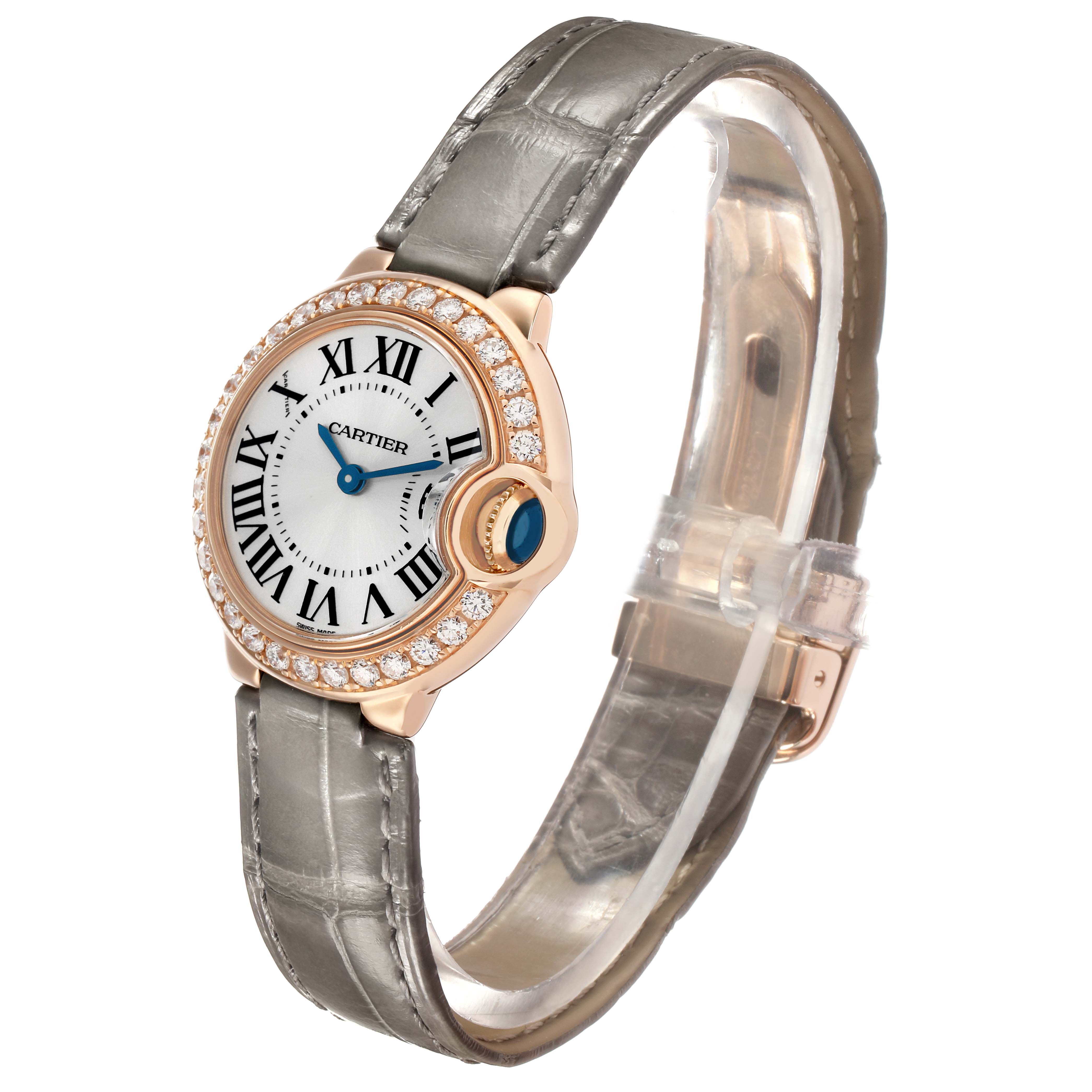 The Ballon Bleu de Cartier watch is shown at an angle, highlighting its round face, Roman numerals, diamond bezel, and leather strap.