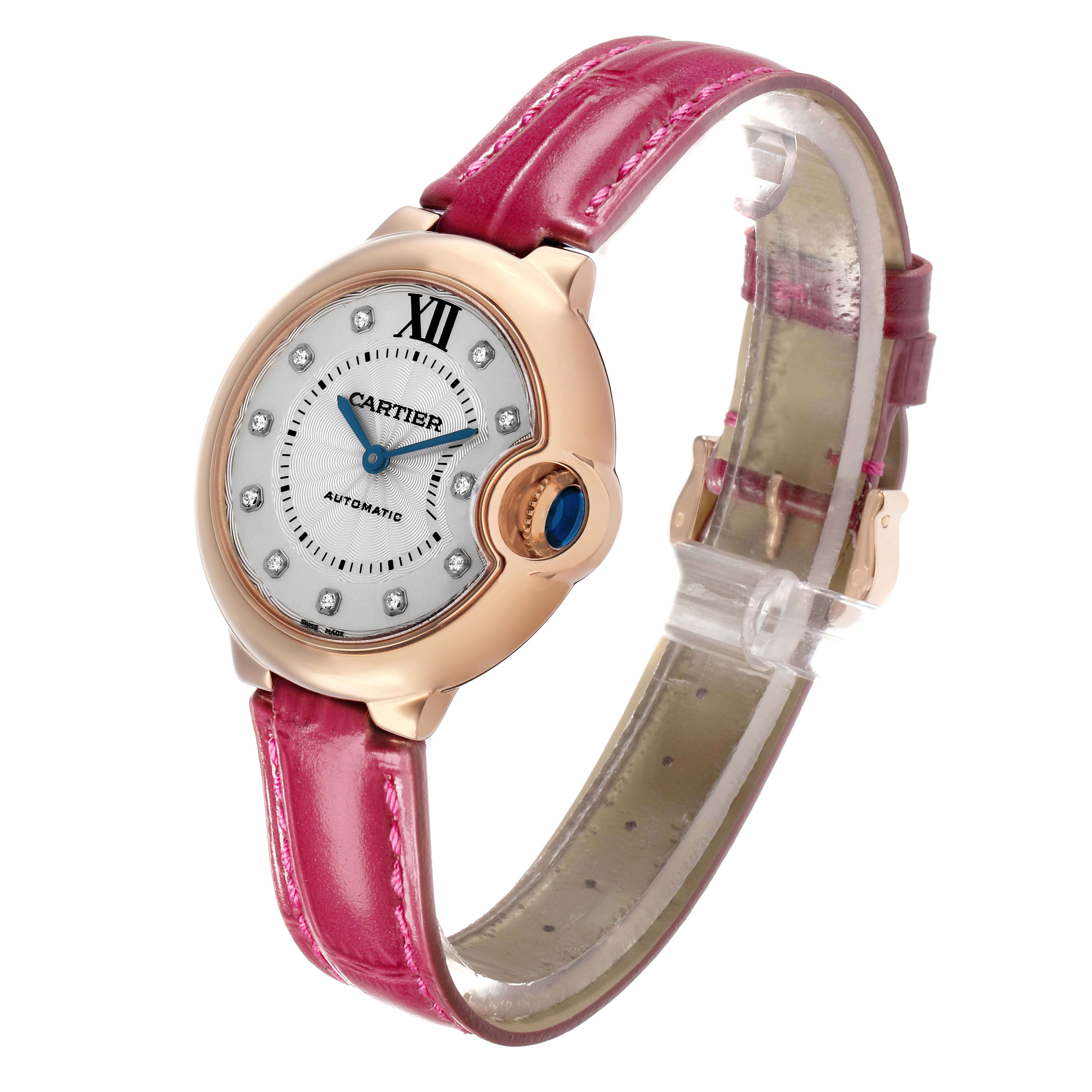 The Cartier Ballon Bleu WE902063 Women's Rose Gold Silver Dial watch is shown at a slight angle, displaying its face, crown, and pink strap.