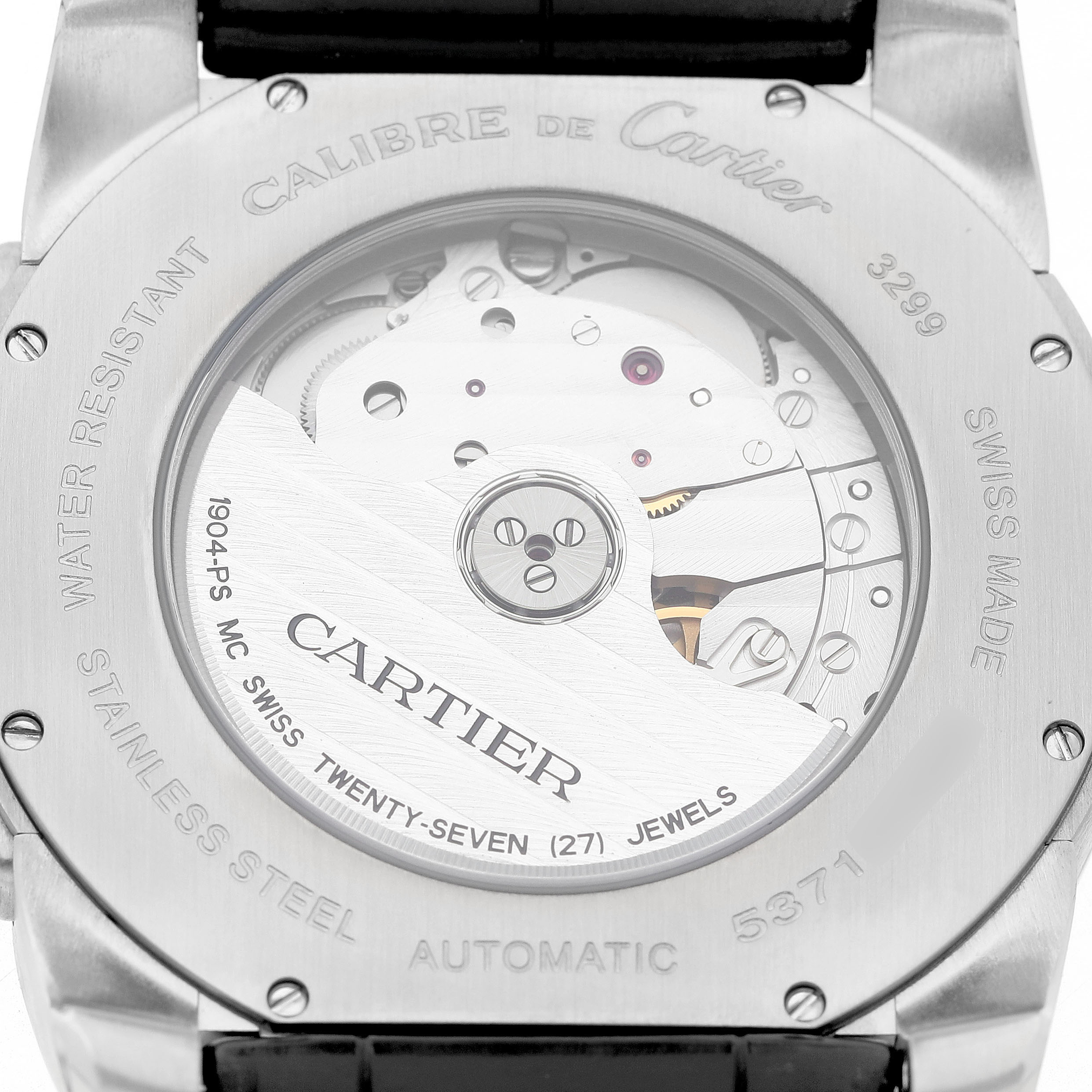 The image shows the back of the Calibre de Cartier watch, displaying the movement and engravings.