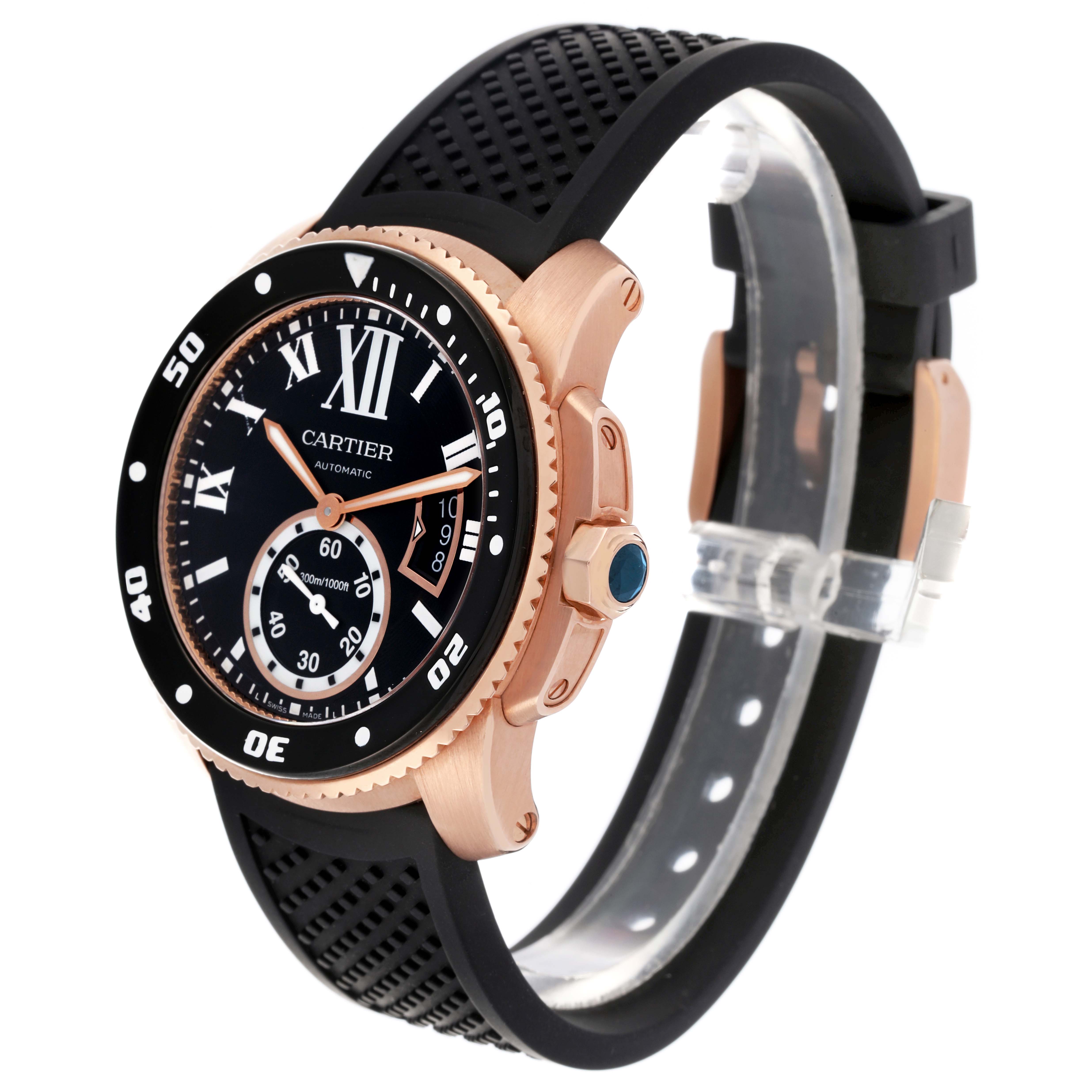 The Calibre de Cartier watch is shown at an angle highlighting the rose gold case, black dial, bezel, and rubber strap.