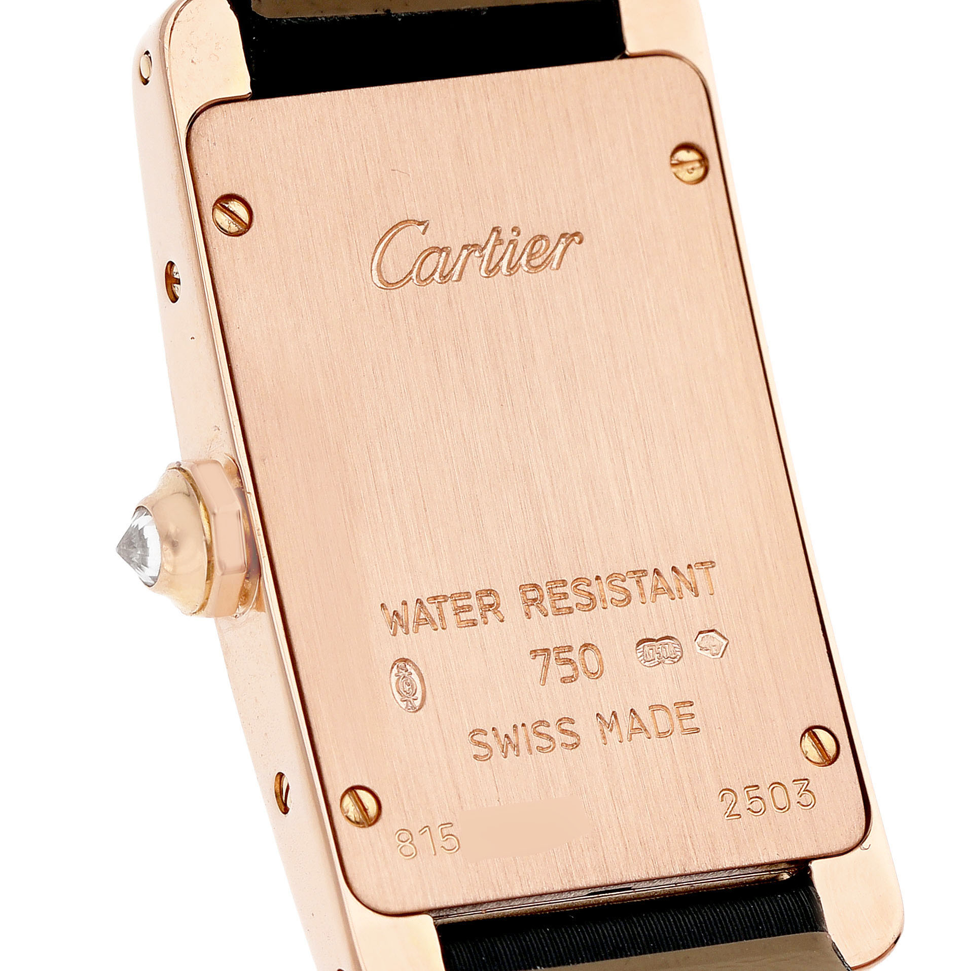 The image shows the back case of a Cartier Tank Americaine WJTA0002 Women's Rose Gold Silver Dial watch, featuring engravings and a visible crown with a gemstone.