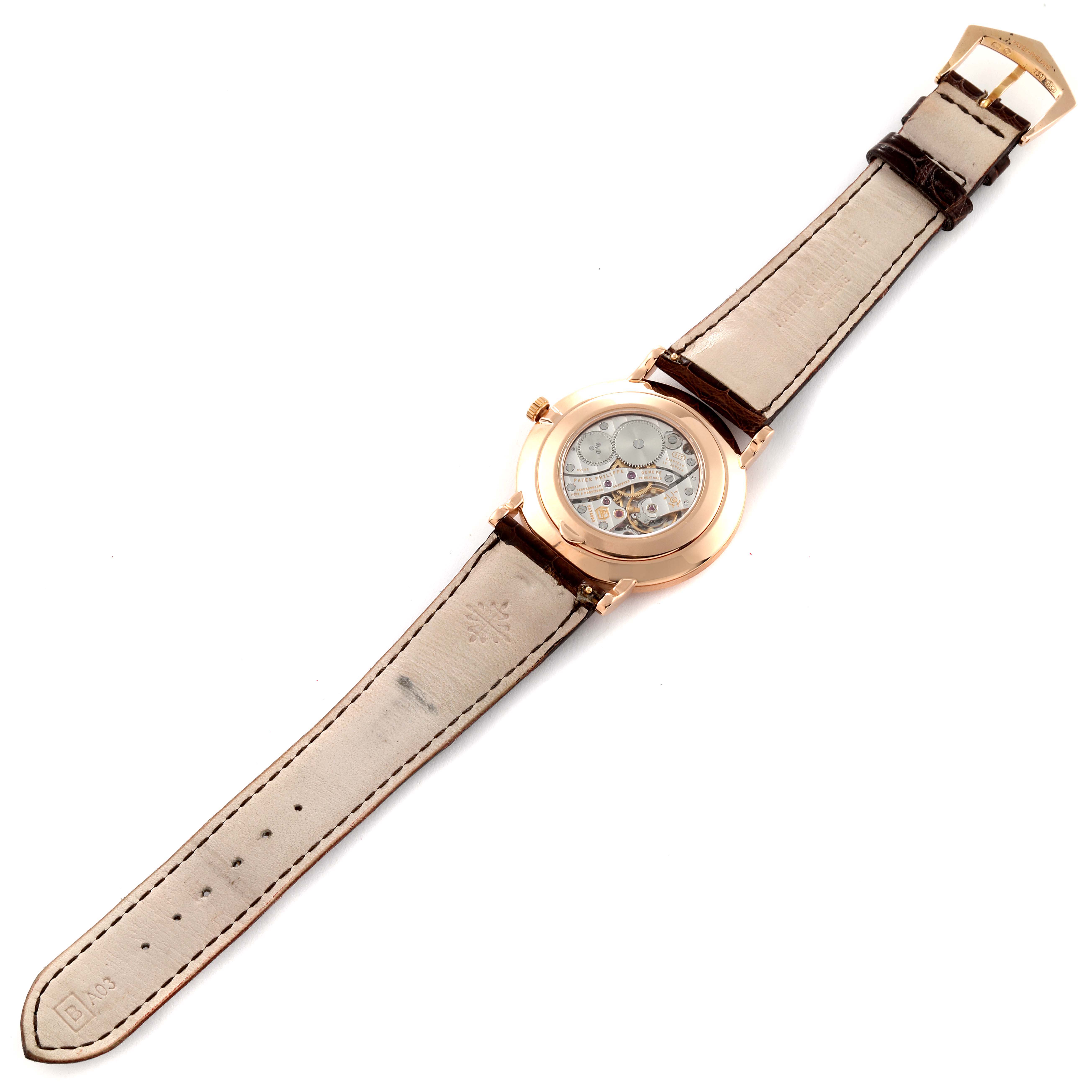 The image shows the back view of a Patek Philippe Calatrava 5119R Men
s Rose Gold White Dial 5119R Men
s Rose Gold White Dial watch, displaying its leather strap and intricate movement.