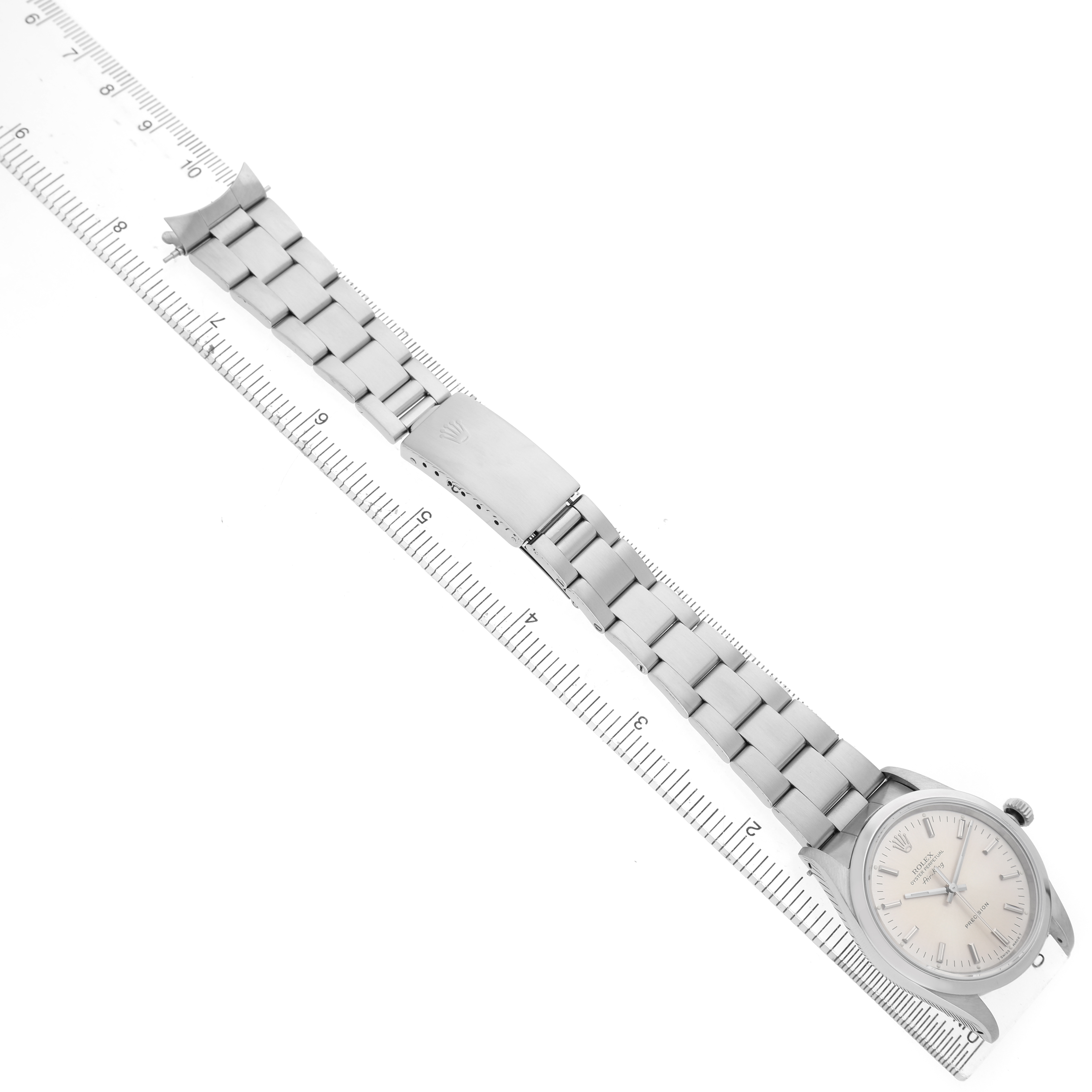 The Rolex Air-King 14000 Men's Stainless Steel Silver Dial watch is shown laid flat from an overhead angle, displaying the face, crown, and entire bracelet alongside a ruler.
