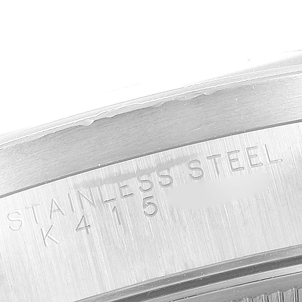 The image shows a close-up of the stainless steel case back of a Rolex Date 15210 Men's Stainless Steel Black Dial 15210 Men's Stainless Steel Black Dial model watch, showing part of its serial number.
