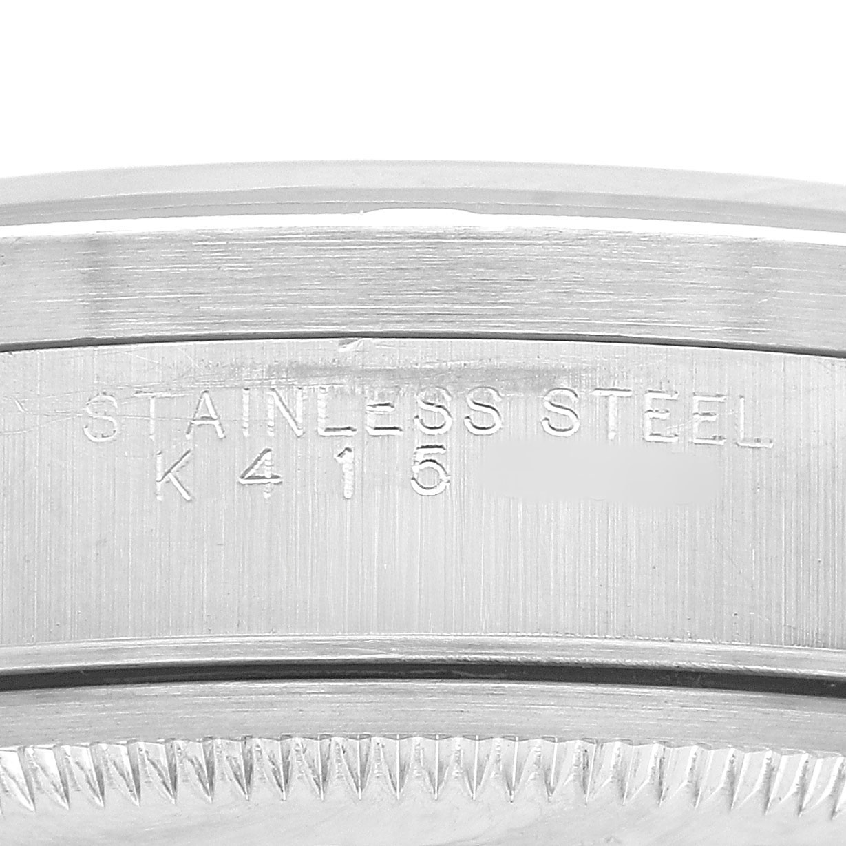 The image shows the side engraving on a stainless steel case of a Rolex Date 15210 Men's Stainless Steel Black Dial model watch.