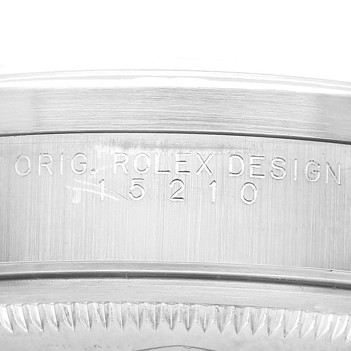 The image shows a close-up of the side of a Rolex Date 15210 Men's Stainless Steel Black Dial model, highlighting the engraved serial number.