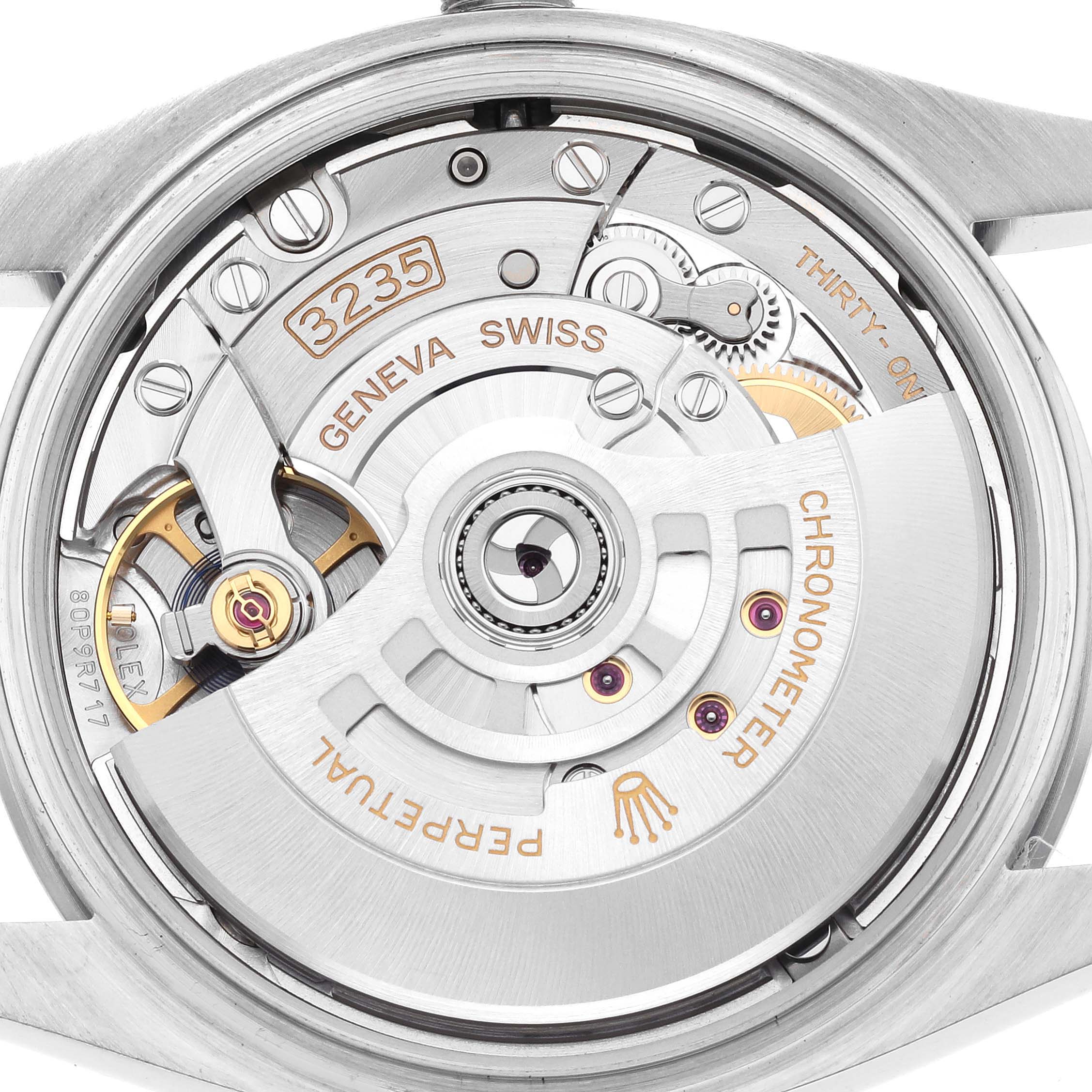 The image shows the movement of a Rolex Datejust 126200 Men
s Stainless Steel Black Dial 126200 Men
s Stainless Steel Black Dial, highlighting the rotor and internal mechanisms from a rear angle.