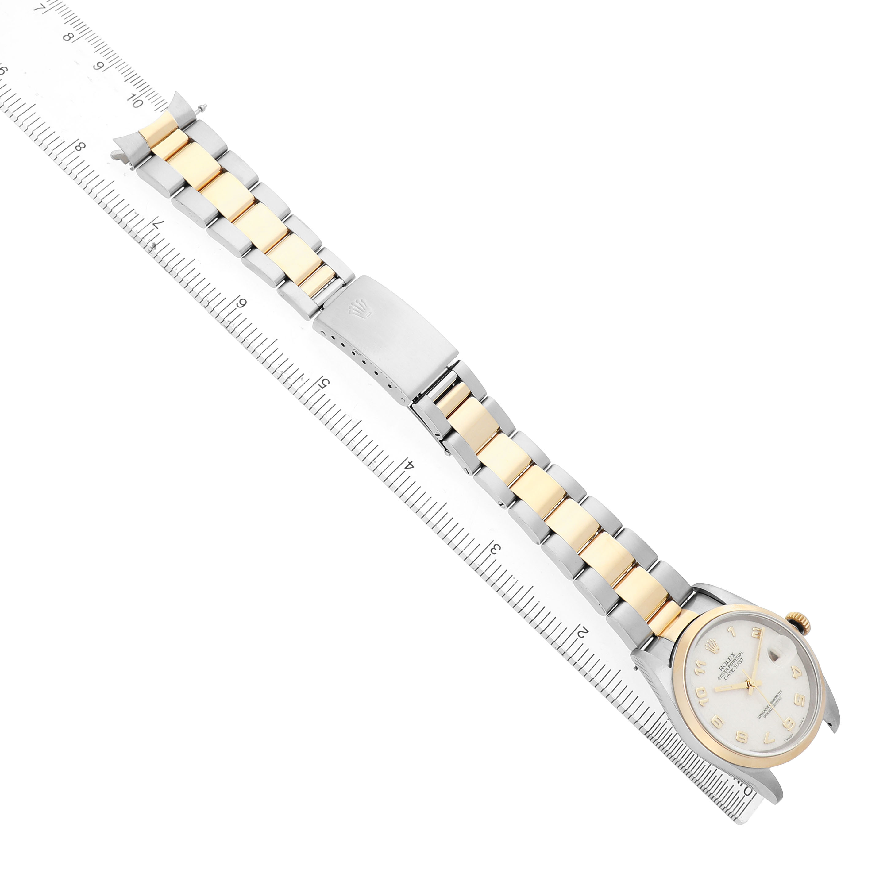 The image shows a Rolex Datejust 116203 Men's Stainless Steel White Dial watch at an angled top-down view, displaying the dial, bracelet, and clasp against a ruler for scale.
