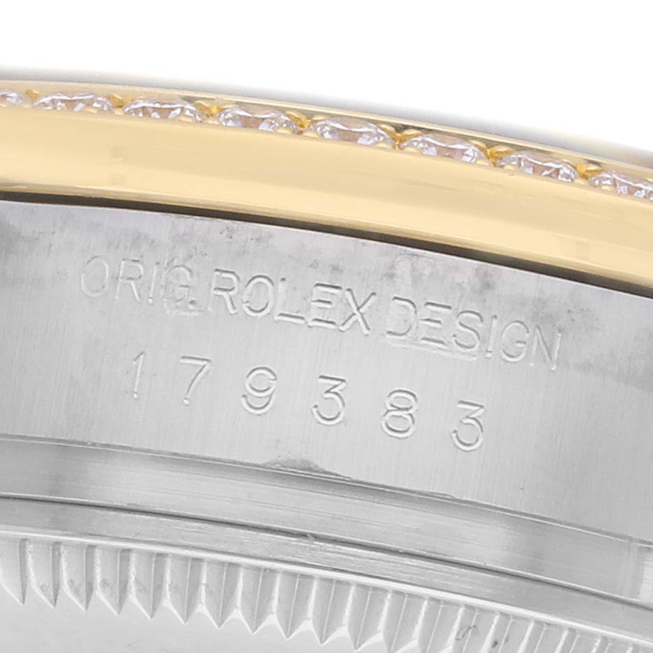 The image shows a close-up of the side of the Rolex Datejust 179383 Women's Steel and Gold (two tone) Champagne Dial case with engravings and a diamond-set bezel.