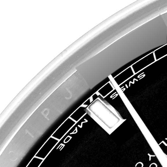 This close-up image of a Rolex Mid-Size 178274 Women's Stainless Steel Black Dial 178274 Women's Stainless Steel Black Dial model watch shows part of the dial, the hands, and the bezel from a top-down angle.