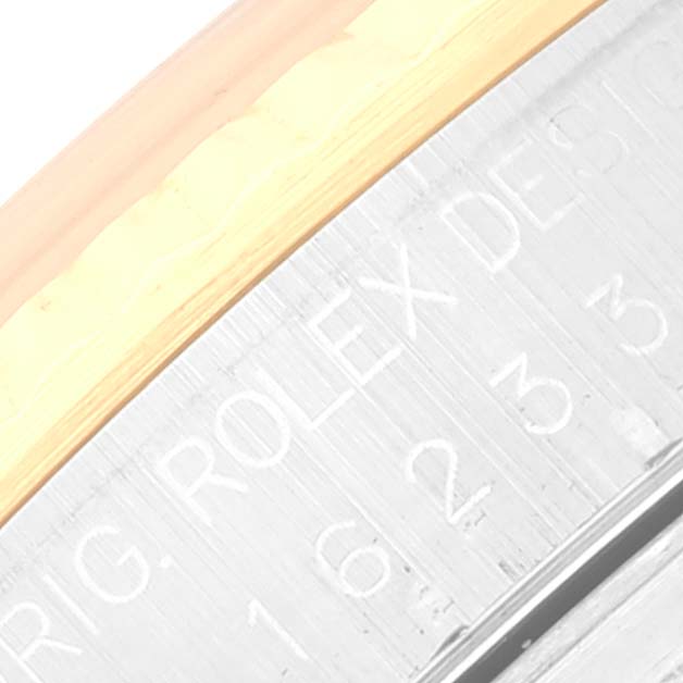 This is a close-up of the side edge of a Rolex Datejust 16233 Men's Steel and Gold (two tone) Champagne Dial 16233 Men's Steel and Gold (two tone) Champagne Dial watch, highlighting the engraved branding and bezel details.