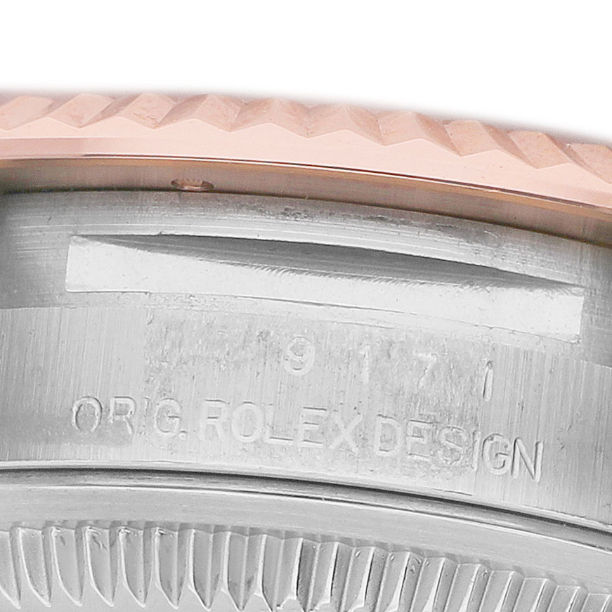 The image shows a close-up of the side view of a Rolex Datejust 279171 Women's Steel and Gold (two tone) Brown Dial's case, highlighting the engraved "ORG. ROLEX DESIGN" and serrated edge.