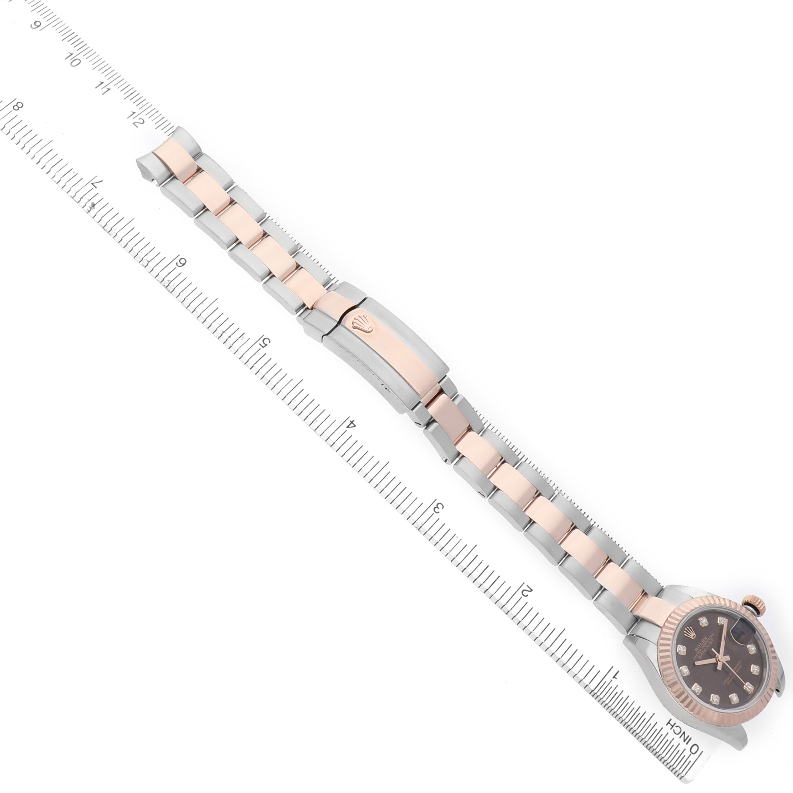 The Rolex Datejust 279171 Women's Steel and Gold (two tone) Brown Dial watch is shown at an angle displaying the face and bracelet, with a ruler for scale.