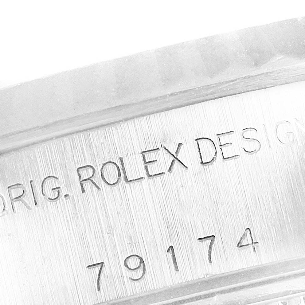 This image shows a close-up of the case side of a Rolex Datejust 79174 Women's Stainless Steel Blue Dial 79174 Women's Stainless Steel Blue Dial watch, highlighting the engraved text and serial number.
