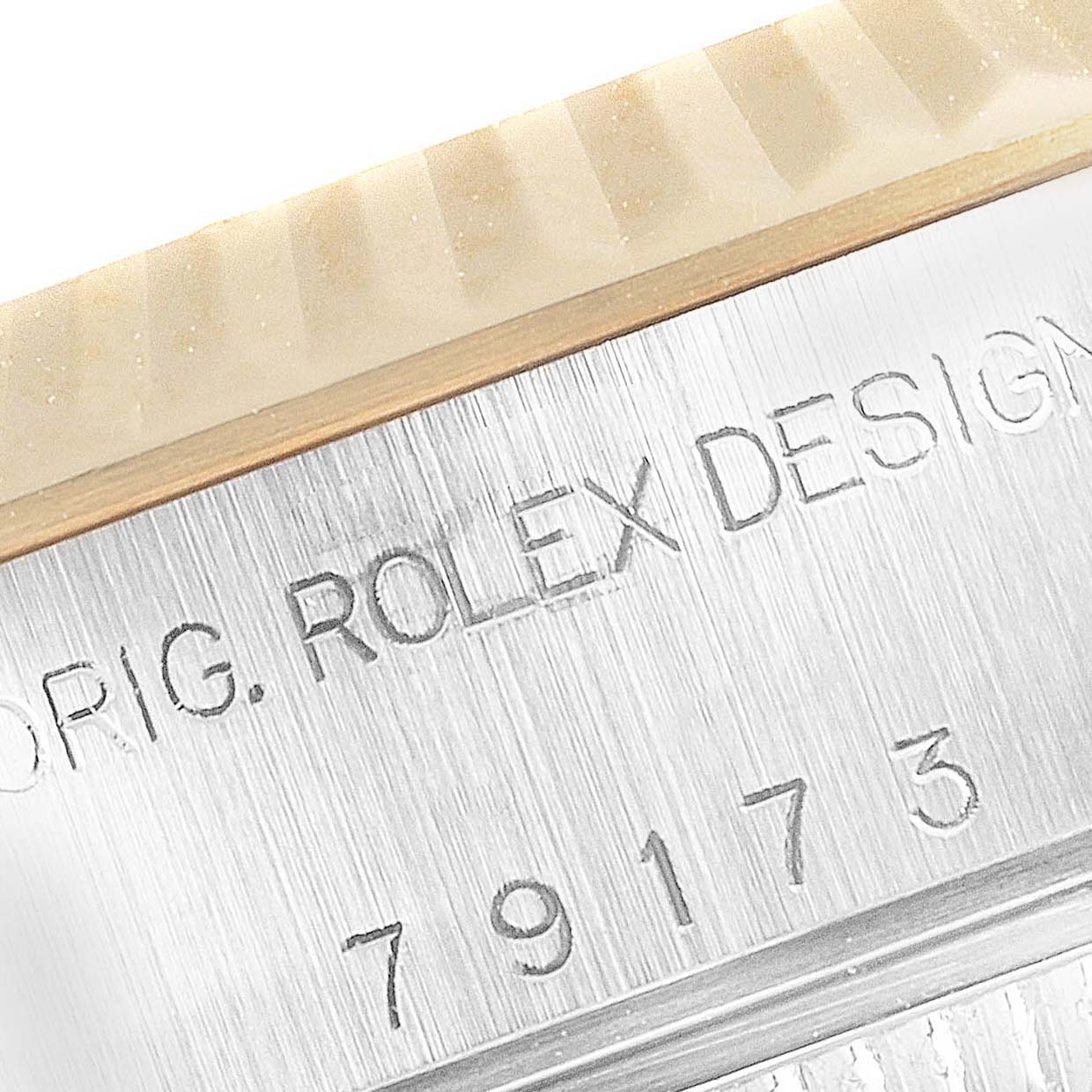 Close-up angle showing the "ORIG. ROLEX DESIGN" inscription and serial number on the case edge of a Rolex Datejust 79173 Women's Steel and Gold (two tone) Champagne Dial 79173 Women's Steel and Gold (two tone) Champagne Dial watch.
