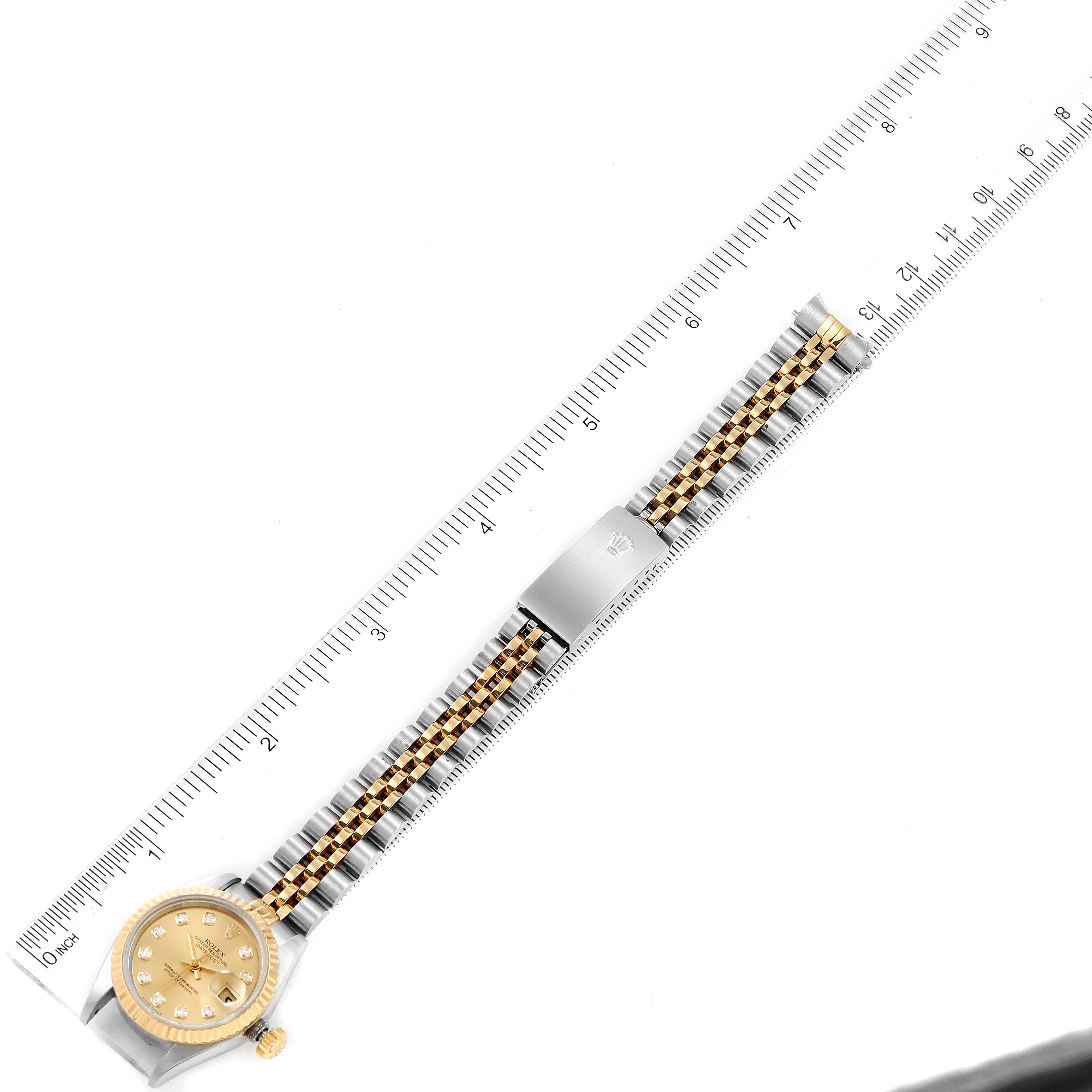 The image shows a Rolex Datejust 79173 Women's Steel and Gold (two tone) Champagne Dial 79173 Women's Steel and Gold (two tone) Champagne Dial watch laid flat with a ruler measuring its entire length from an aerial view.