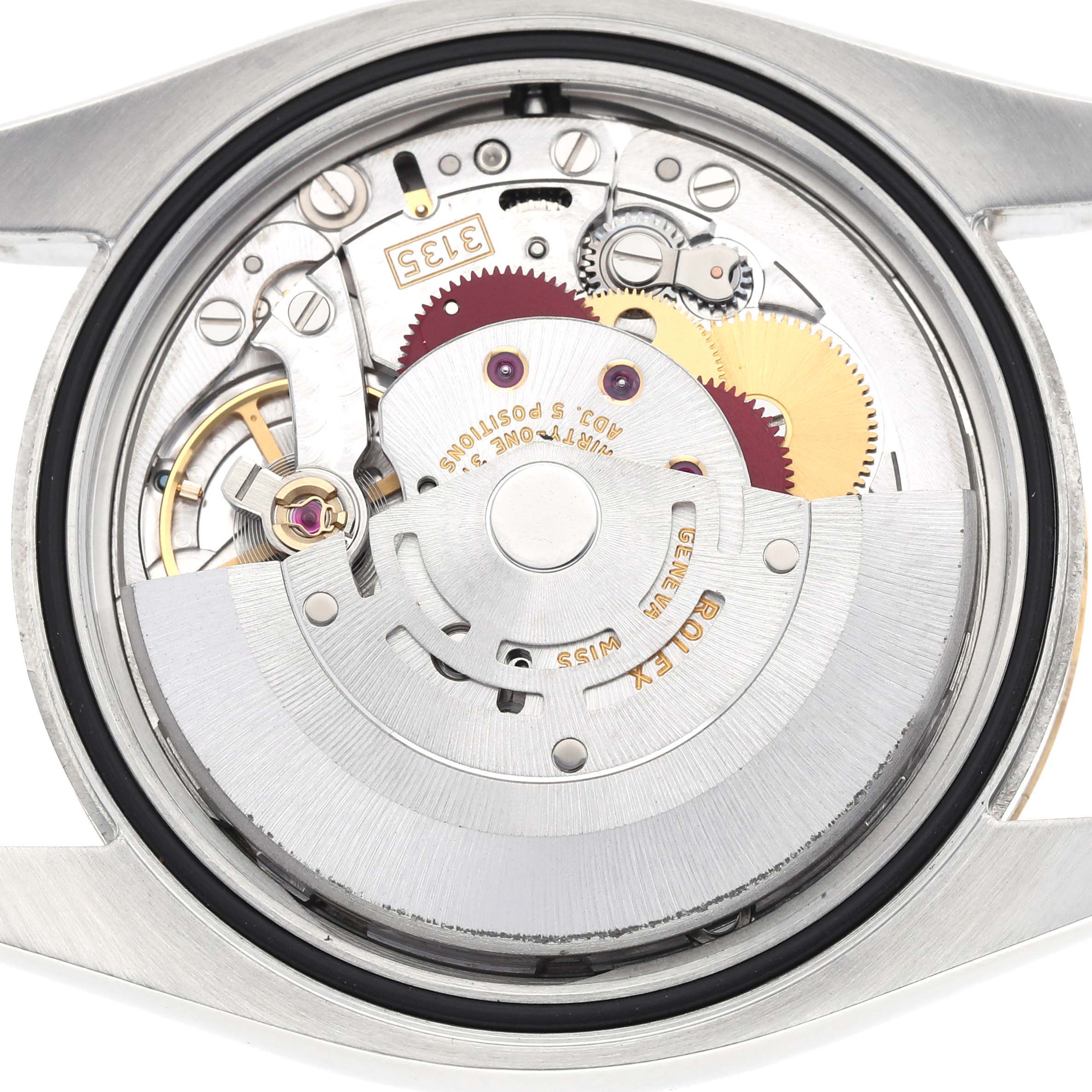 The image shows the internal movement of a Rolex Datejust 116233 Men's Steel and Gold (two tone) Silver Dial watch, displaying gears and the rotor from the back angle.