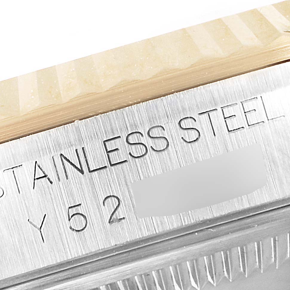 This close-up image shows the engraved stainless steel side of a Rolex Datejust 16233 Men's Steel and Gold (two tone) Champagne Dial 16233 Men's Steel and Gold (two tone) Champagne Dial watch, highlighting part of its serial number.