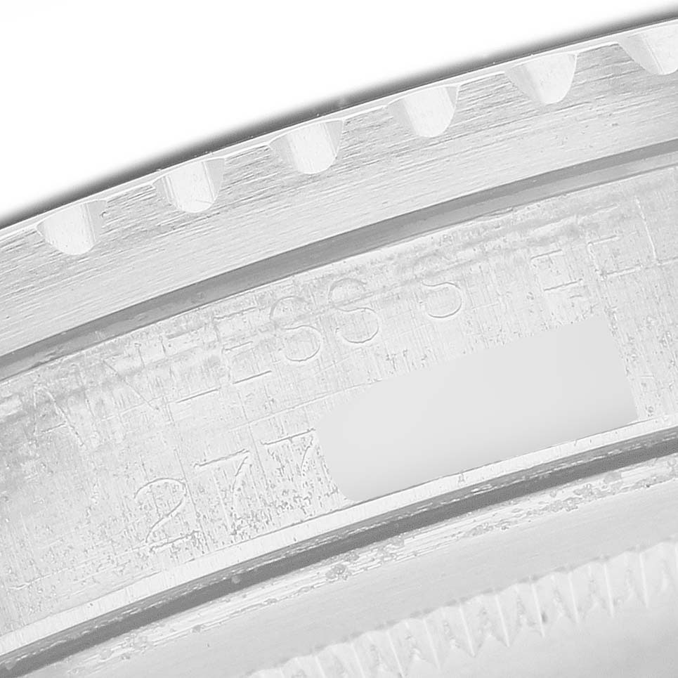 The image shows a close-up of the engravings on the bezel edge of a Rolex Vintage Collection 1675 Men's Stainless Steel Black Dial watch, highlighting "STAINLESS STEEL."