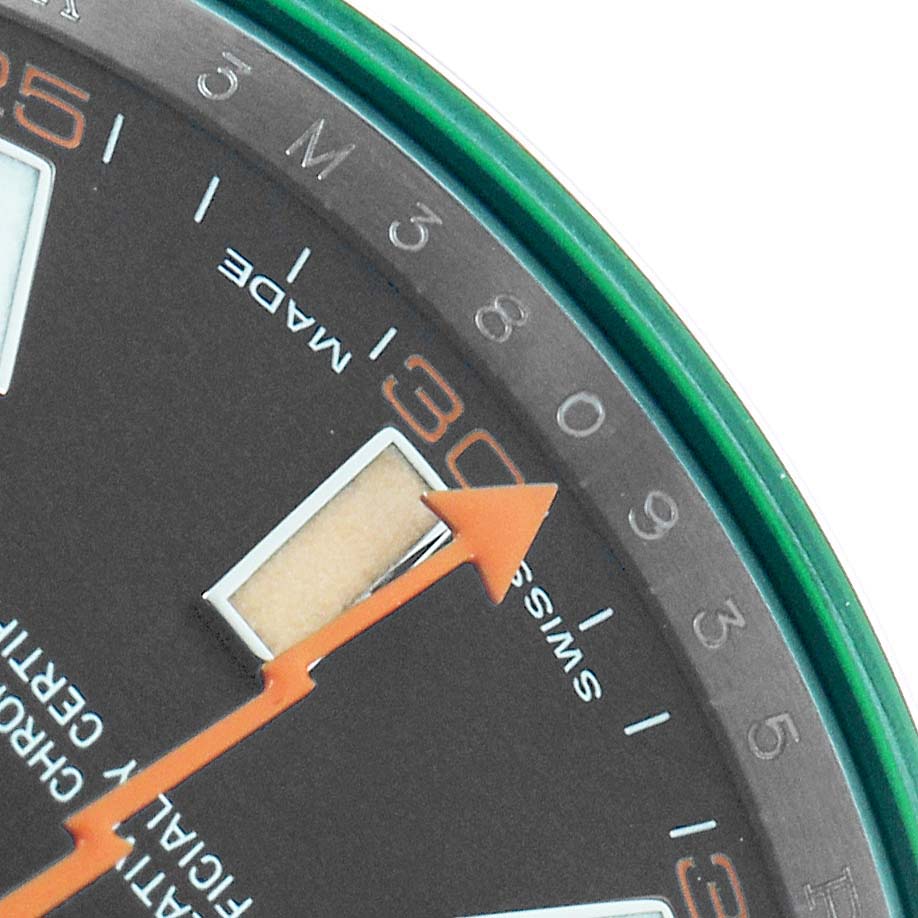 The image shows the edge of the Rolex Milgauss 116400GV Men's Stainless Steel Black Dial dial, highlighting the minute markers, indices, and orange lightning bolt second hand.