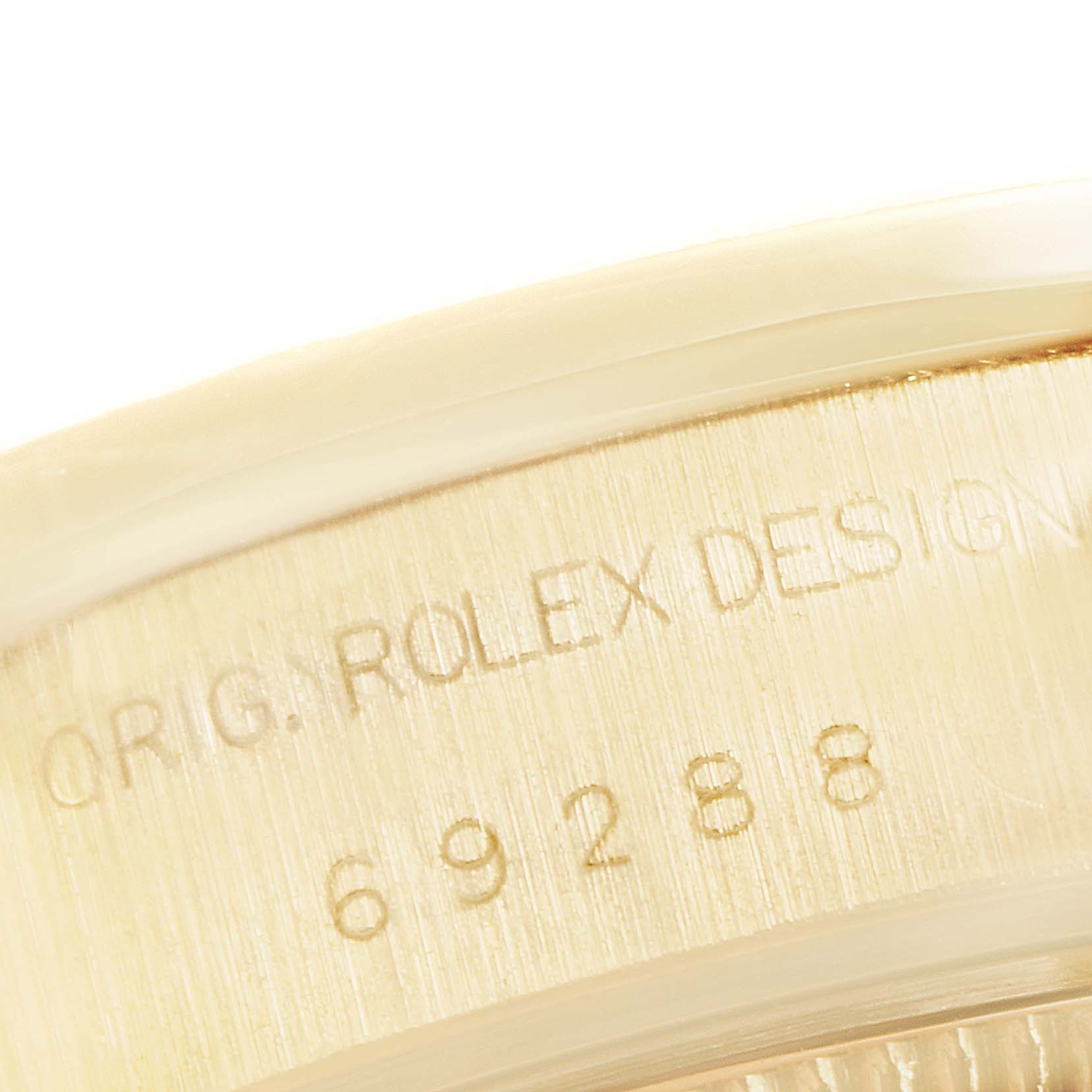 This image shows a close-up of the engraved bezel and case side of a Rolex President 69288 Women
s White Gold Champagne Dial 69288 Women
s White Gold Champagne Dial watch.