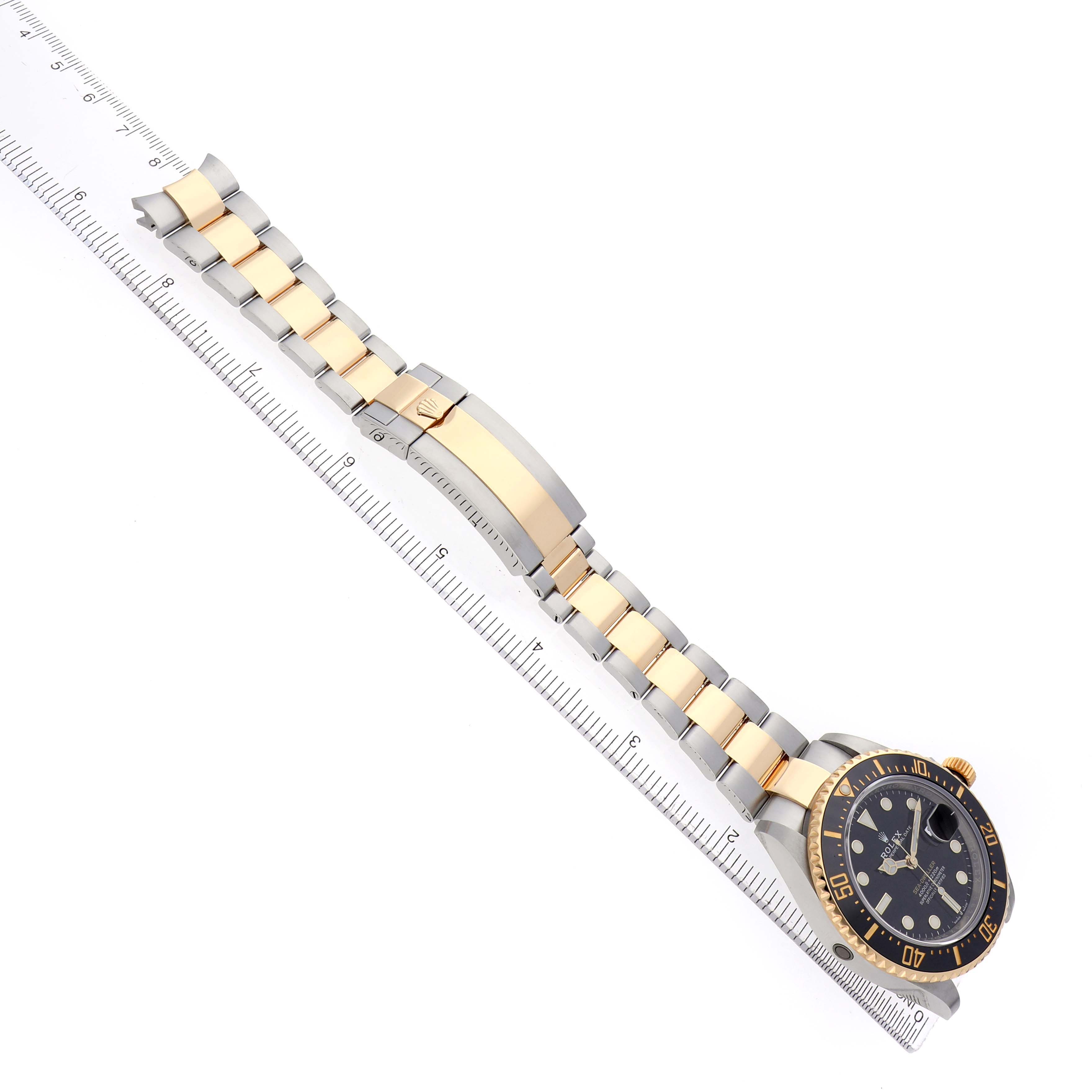 The Rolex Sea-Dweller 126603 Men's Steel and Gold (two tone) Black Dial watch is shown from a top view, displaying the bracelet and face alongside a ruler.
