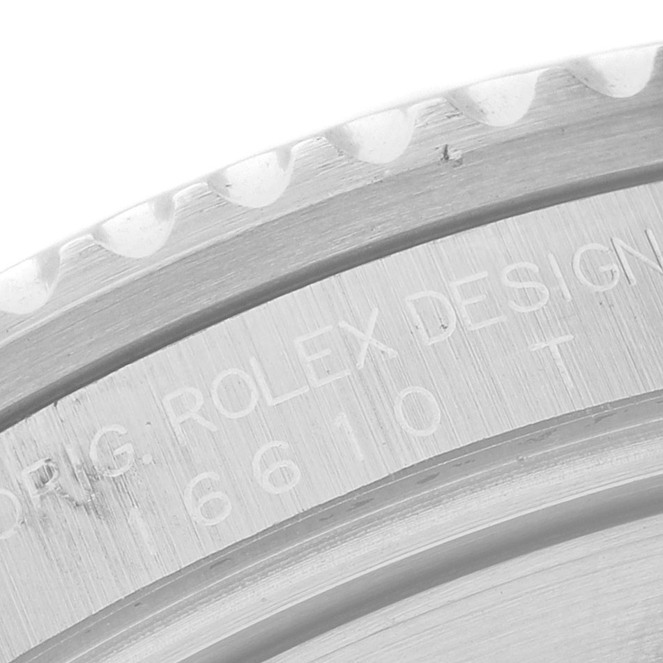 The image shows a close-up of the bezel and engraved edge of a Rolex Submariner 16610 Men's Stainless Steel Black Dial, highlighting its intricate details.